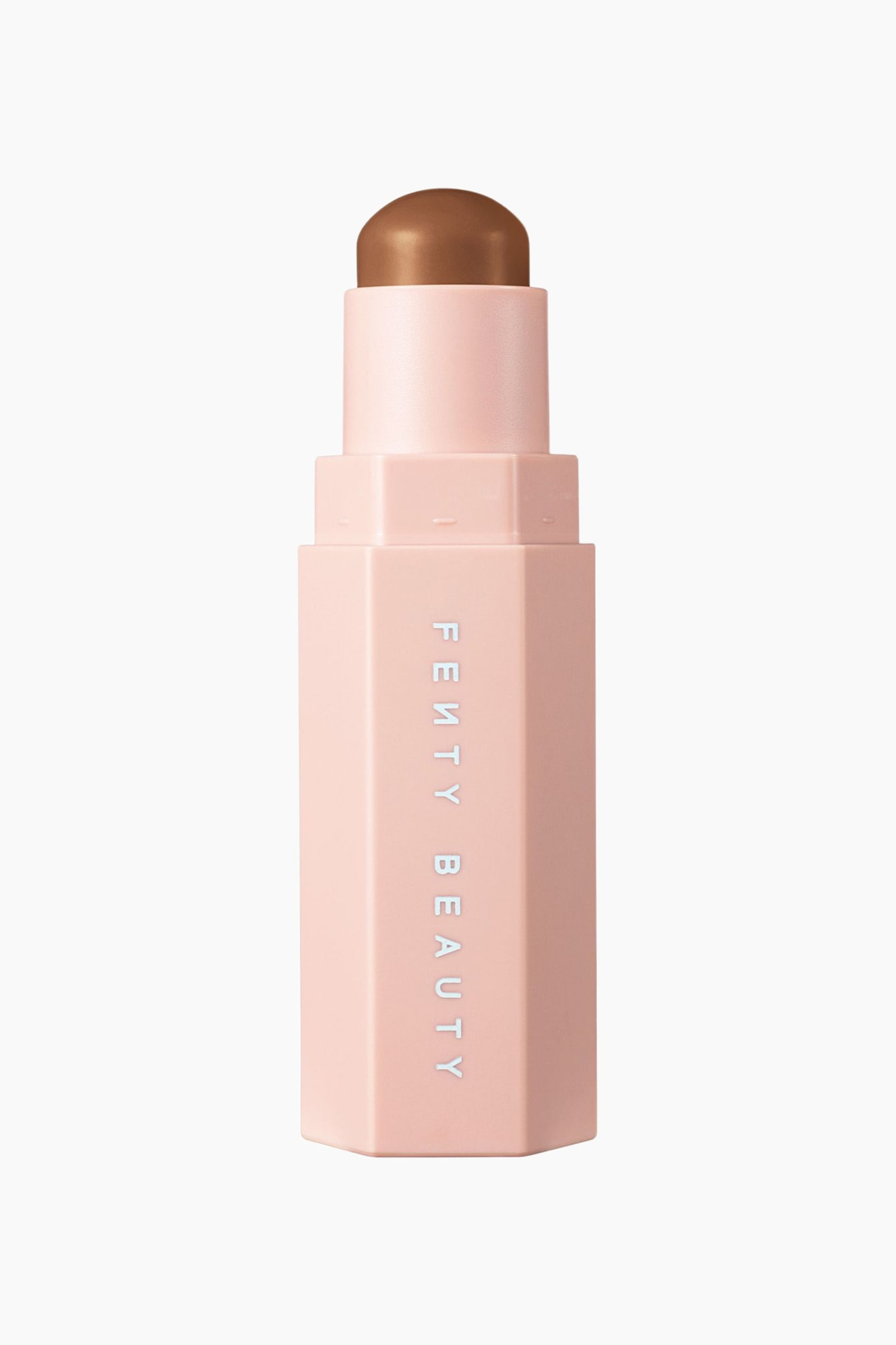 En contour stick i et lyserÃ¸dt, sekskantet etui stÃ¥r lodret og viser brandnavnet "FENTY BEAUTY" trykt lodret i hvidt pÃ¥ forsiden. Etuiet er Ã¥bent, og et cylindrisk inderrÃ¸r strÃ¦kker sig opad og afslÃ¸rer et kuppelformet contourprodukt i cremet mediumbrun.