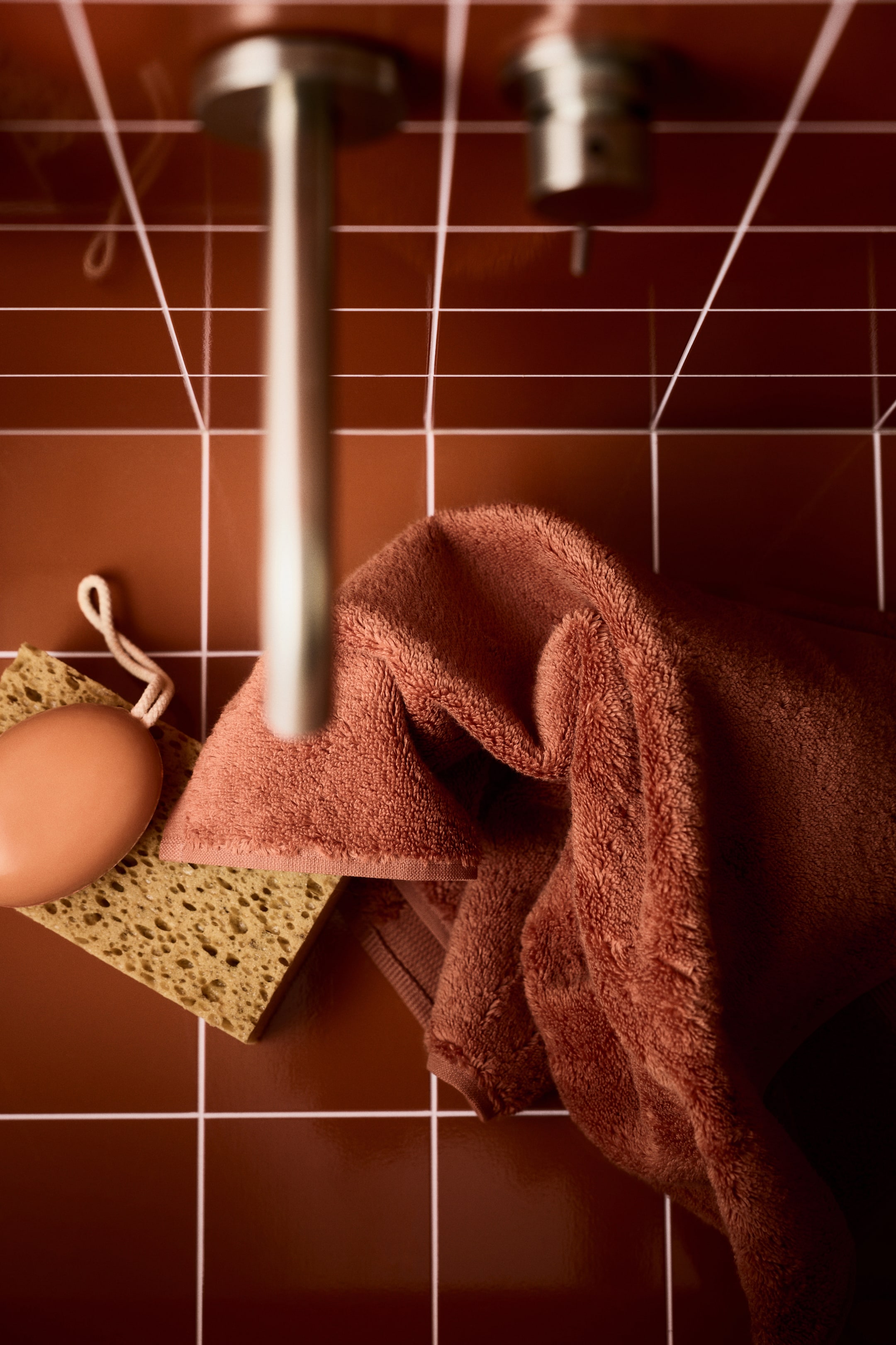 View larger image: A terracotta-colored terry cloth towel is draping, showing its soft texture.