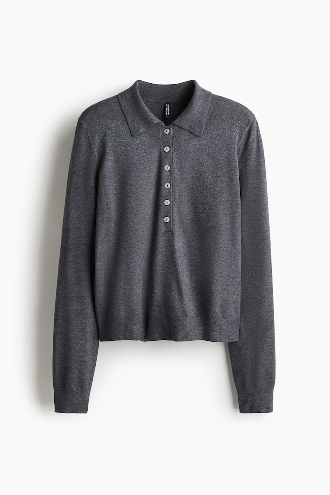 A dark gray polo shirt, made from a fine knit, is shown from the front. It is featuring a collar, a button placket with six light-colored buttons, gently dropped shoulders, and long sleeves with ribbed cuffs. A ribbed hem is also visible. - 1