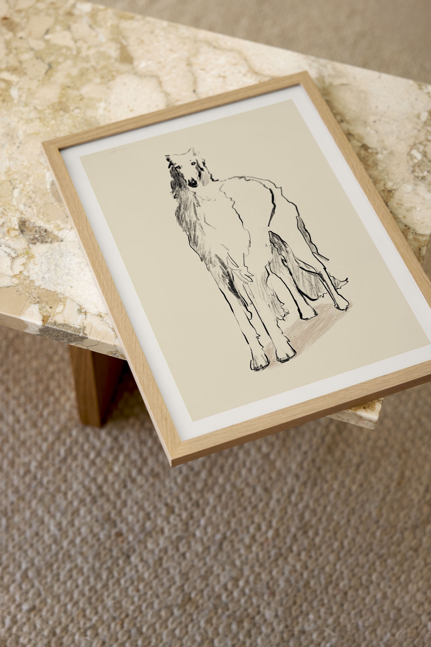 Una stampa artistica mostra uno schizzo minimalista in stile carboncino di un cane Borzoi in piedi, realizzato con linee nere sciolte e ombreggiature su uno sfondo beige chiaro. La stampa presenta un ampio bordo bianco pulito che incornicia l'opera centrale.