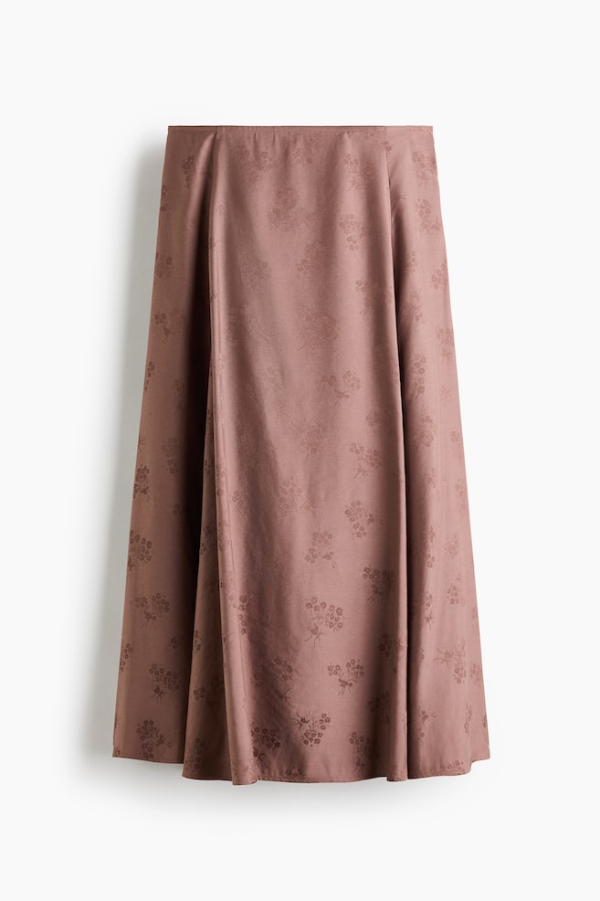 A skirt is presenting in a muted brownish-pink color with a subtle, tone-on-tone botanical jacquard pattern. It is featuring a flared A-line silhouette, draping down to a midi length, and is shown facing front. - 1