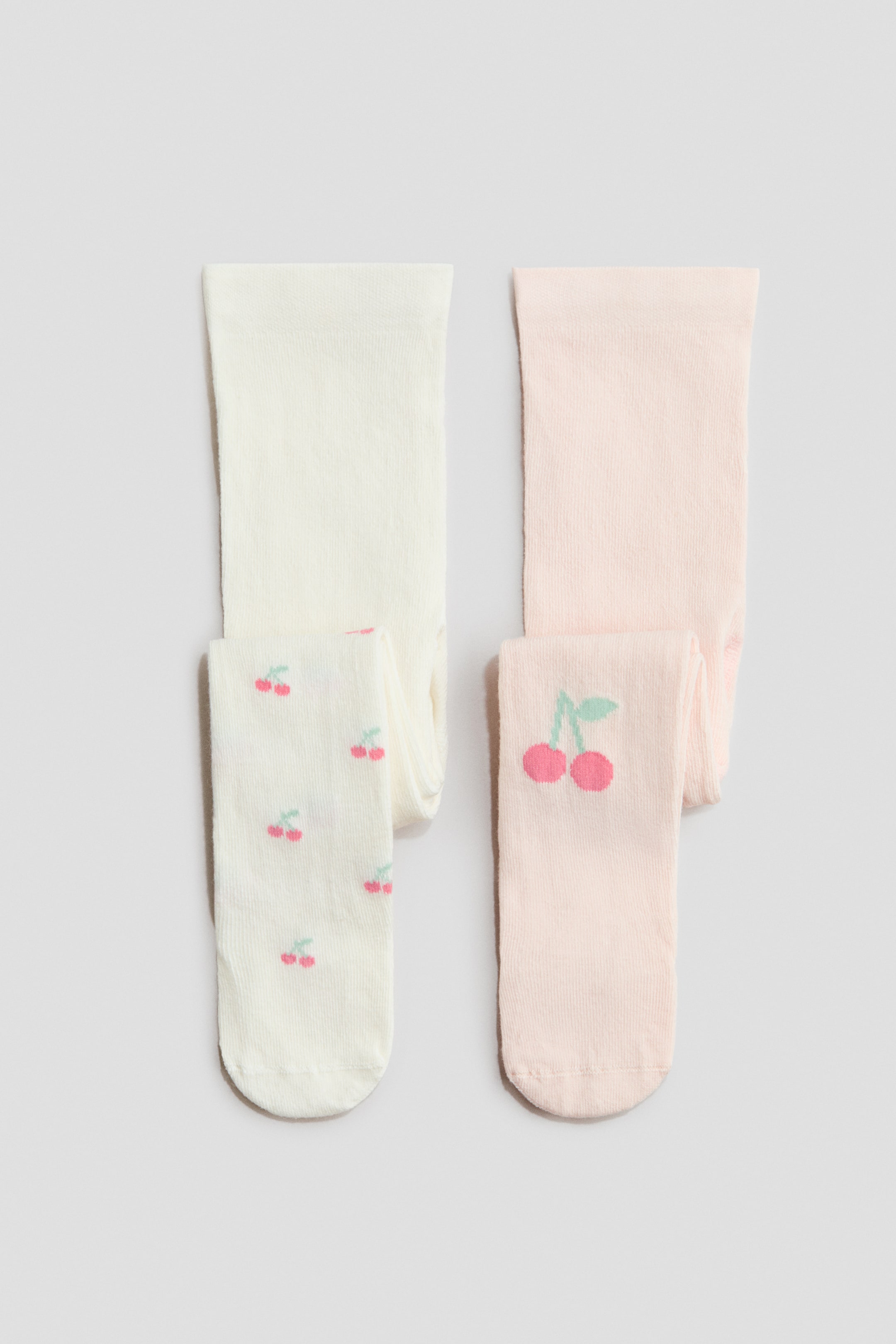 View larger image: One pair is off-white with a repeating small cherry pattern, and the other is light pink featuring a single large cherry design on the foot.
