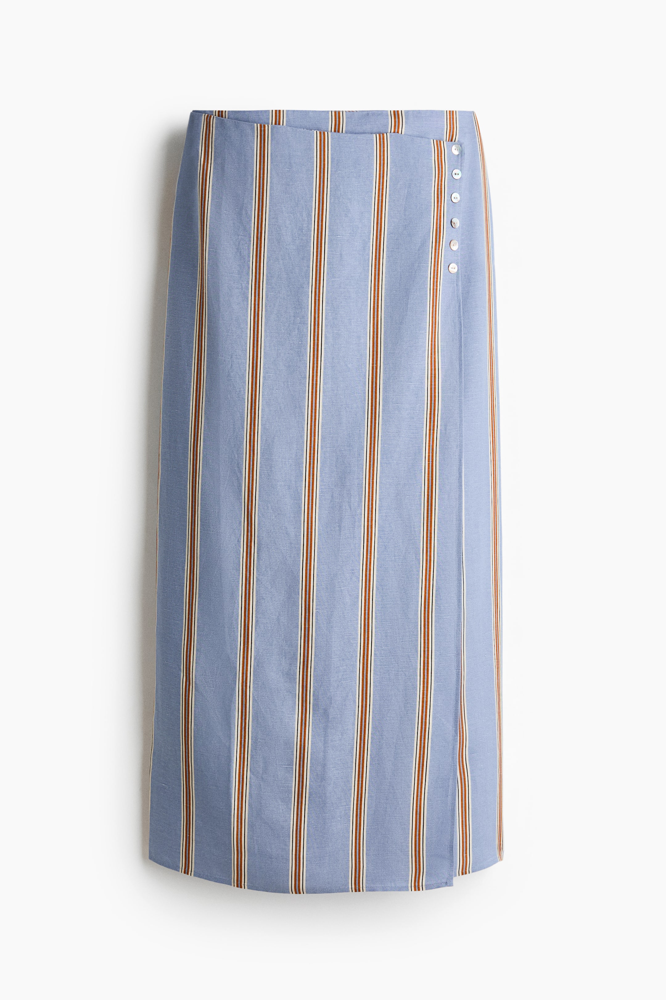 View larger image: FRONT view of a calf-length skirt, featuring a high waist and light blue fabric with a visible airy weave texture. It showcases vertical brown and white stripes and a sewn-in wrapover front, accented by a row of five small white decorative buttons on the right side.