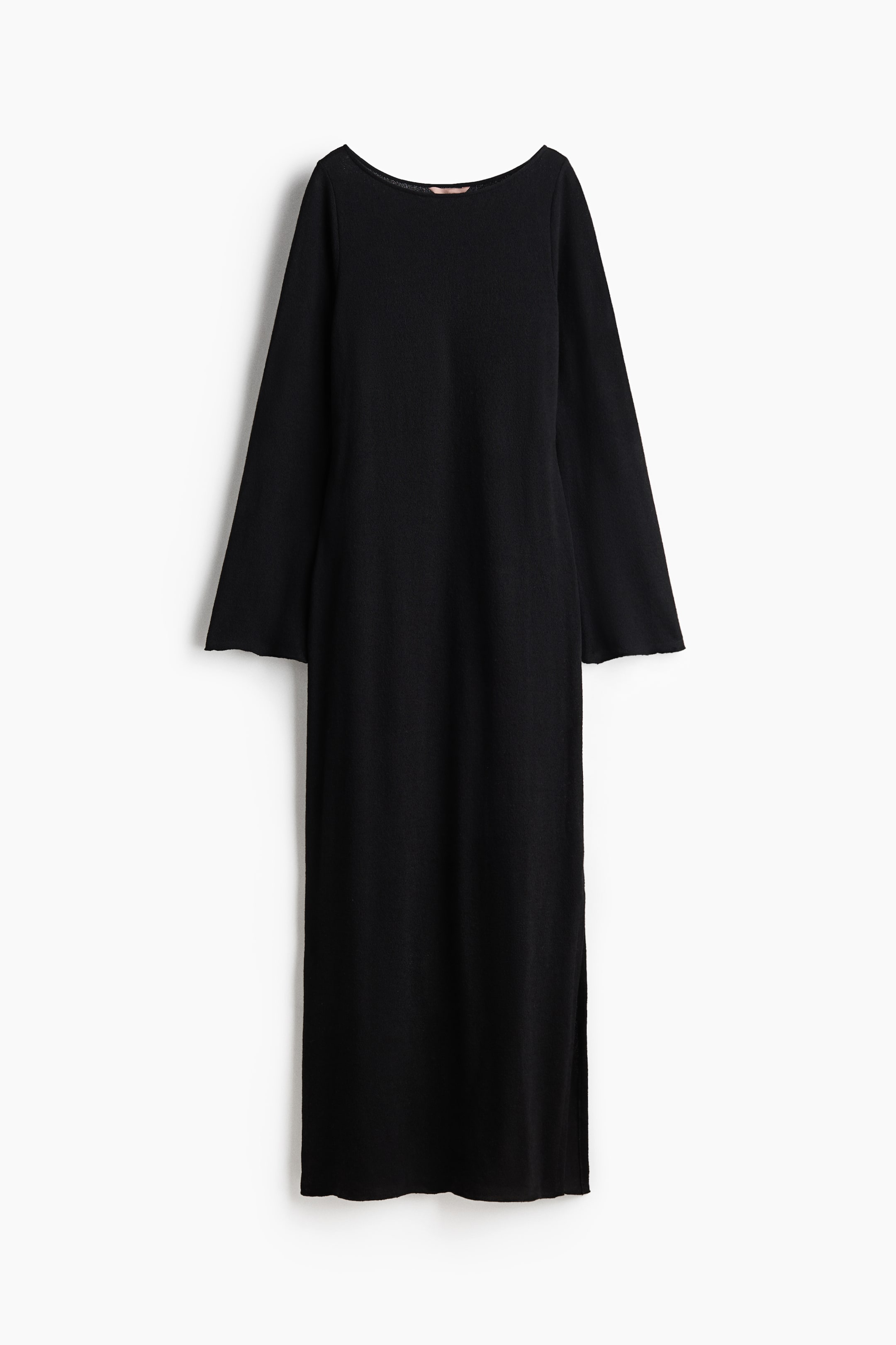 View larger image: The black dress is showcased from the front, featuring a boat neck and long sleeves with raw edges. It highlights a straight, relaxed fit and a midi length, complete with side slits and a raw hem.