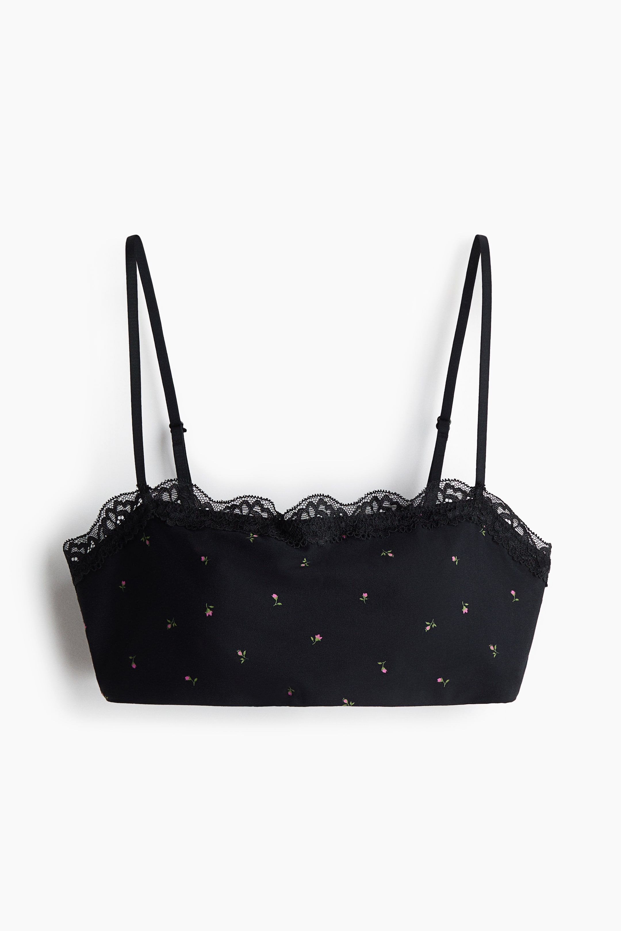 View larger image: A front-facing black bralette features a scattered pattern of small pink and green floral motifs. The top edge is finished with a scalloped black lace trim, and the piece is designed with thin, adjustable spaghetti straps.