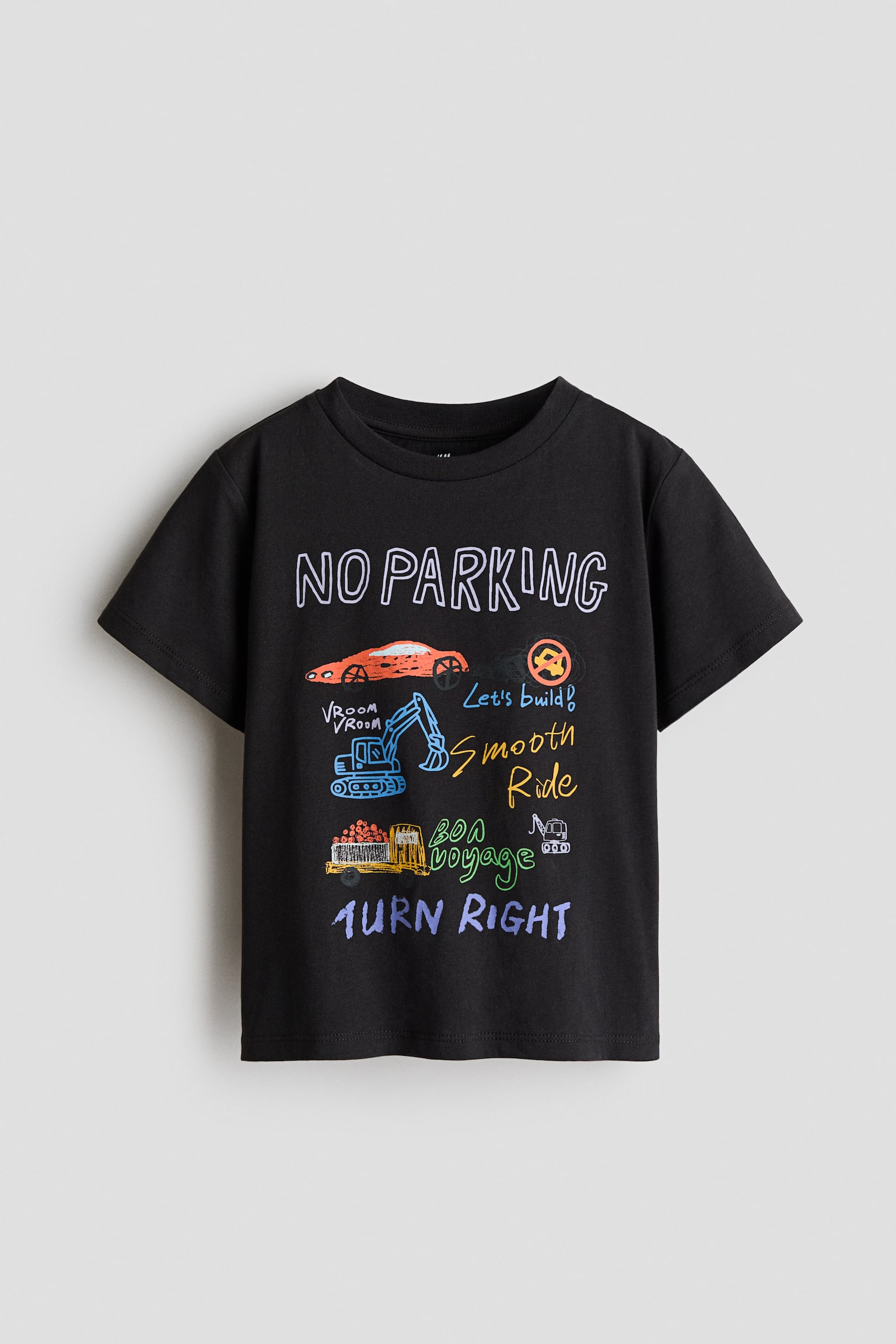 黑色短袖T恤的正面展示了一幅色彩缤纷的图案，配有圆领。图案包括橙色汽车、蓝色挖掘机和黄色卡车的轮廓，以及诸如“禁止停车”、“开始建造！”、“顺畅行驶”、“一路顺风”和“右转”等各种鲜艳颜色的文字。 - 1