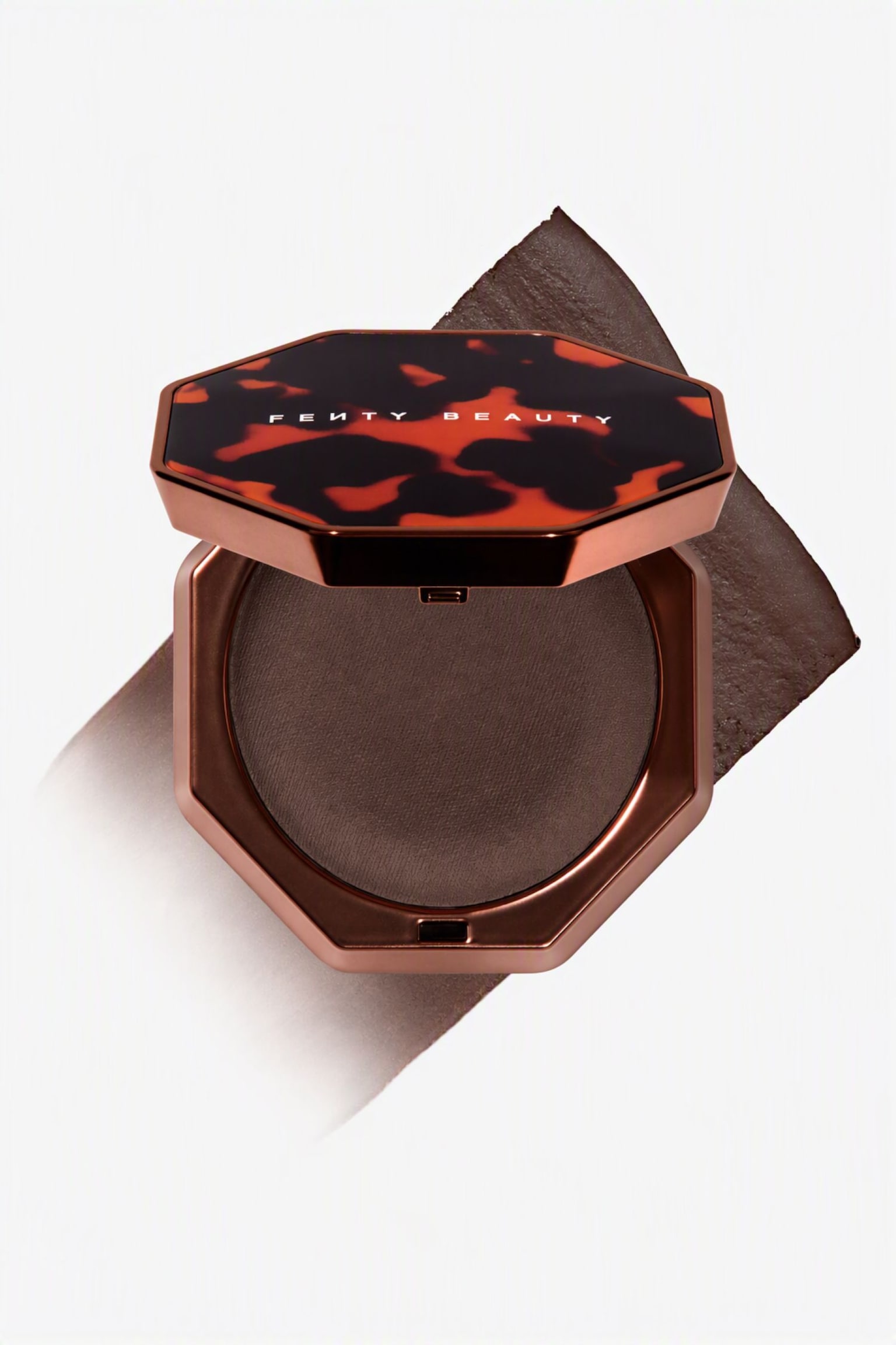 En Ã¶ppen, oktagonal kompakt i metallisk brons visar en djupbrun pressad bronzer i en rund dosa, samtidigt som den vilar ovanpÃ¥ ett diagonalt, texturerat swatch i den matchande nyansen. Det delvis uppfÃ¤llda locket visar ett svart- och bÃ¤rnstensfÃ¤rgat skÃ¶ldpaddsmÃ¶nster med varumÃ¤rkesnamnet tryckt i vitt Ã¶ver mitten. - 1