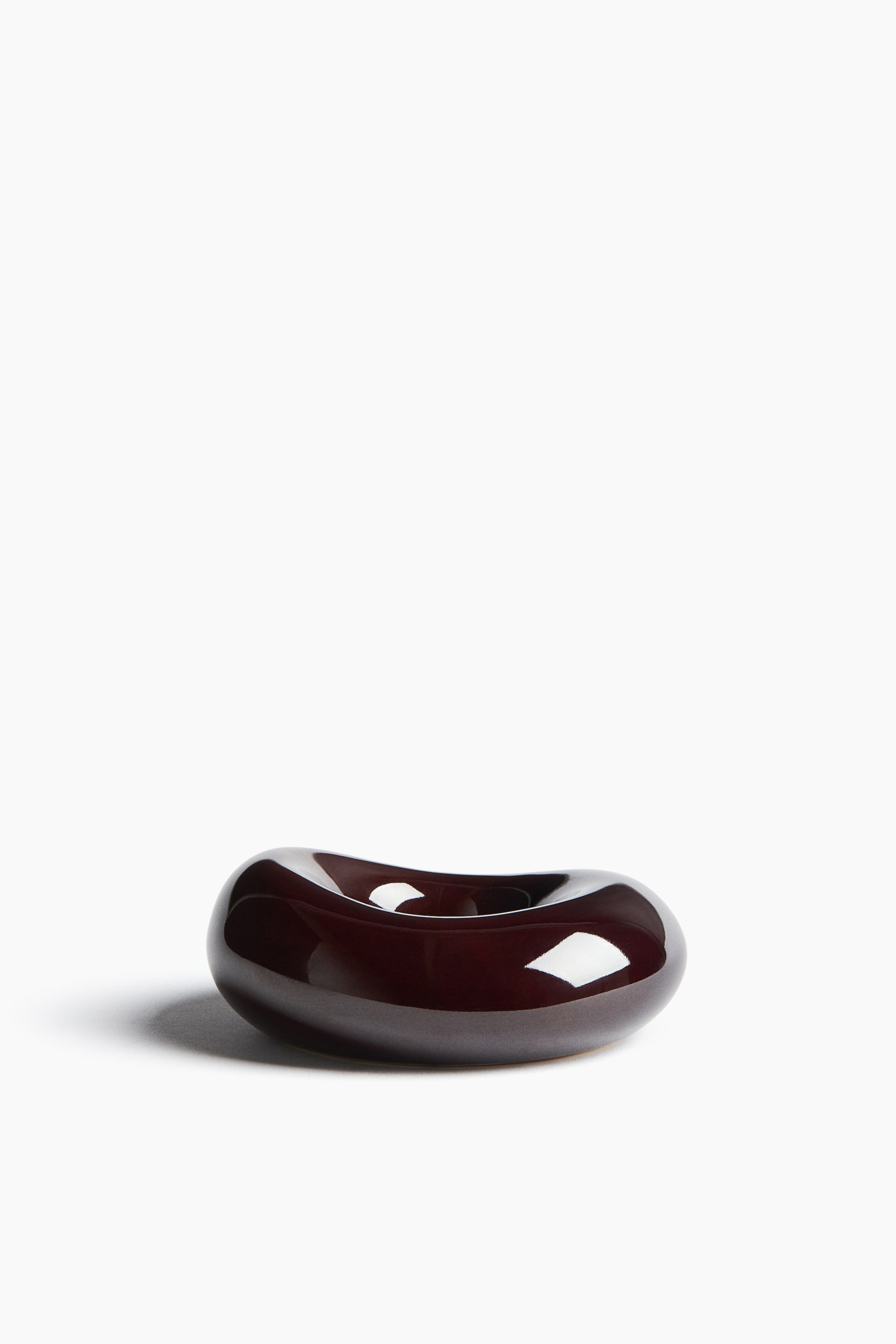 View larger image: A dark, deep reddish-brown object is presenting with a highly reflective, glossy finish. It is featuring an organic, rounded form with an irregular central opening, resembling a smooth, abstract sculpture.