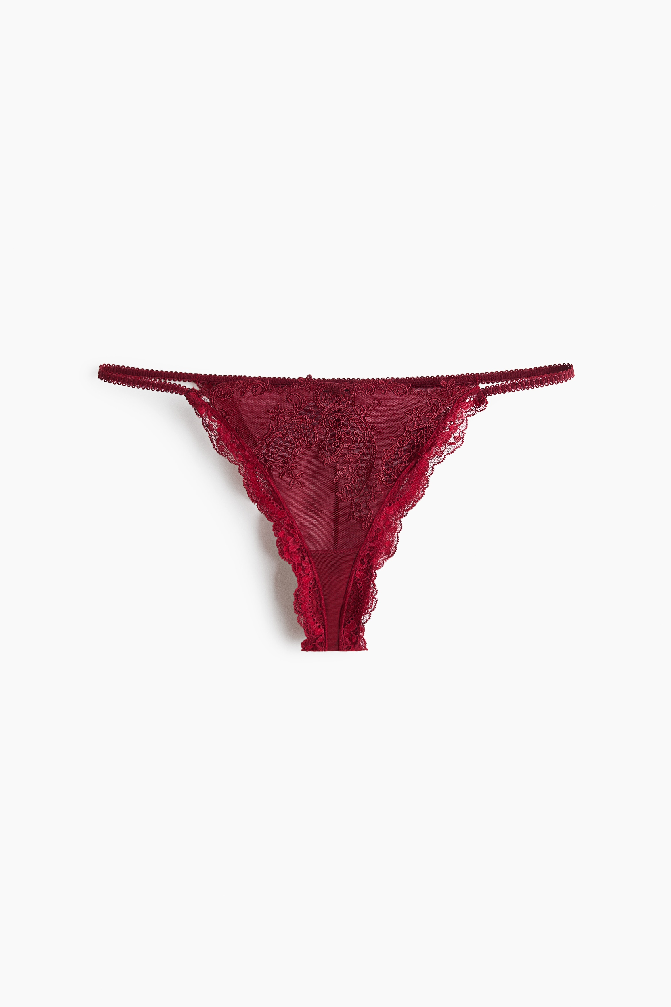 Dark red briefs in embroidered lace and sheer mesh are being worn by the model, featuring a low-rise waist and thin side straps. A matching lace bra is partially visible at the top.