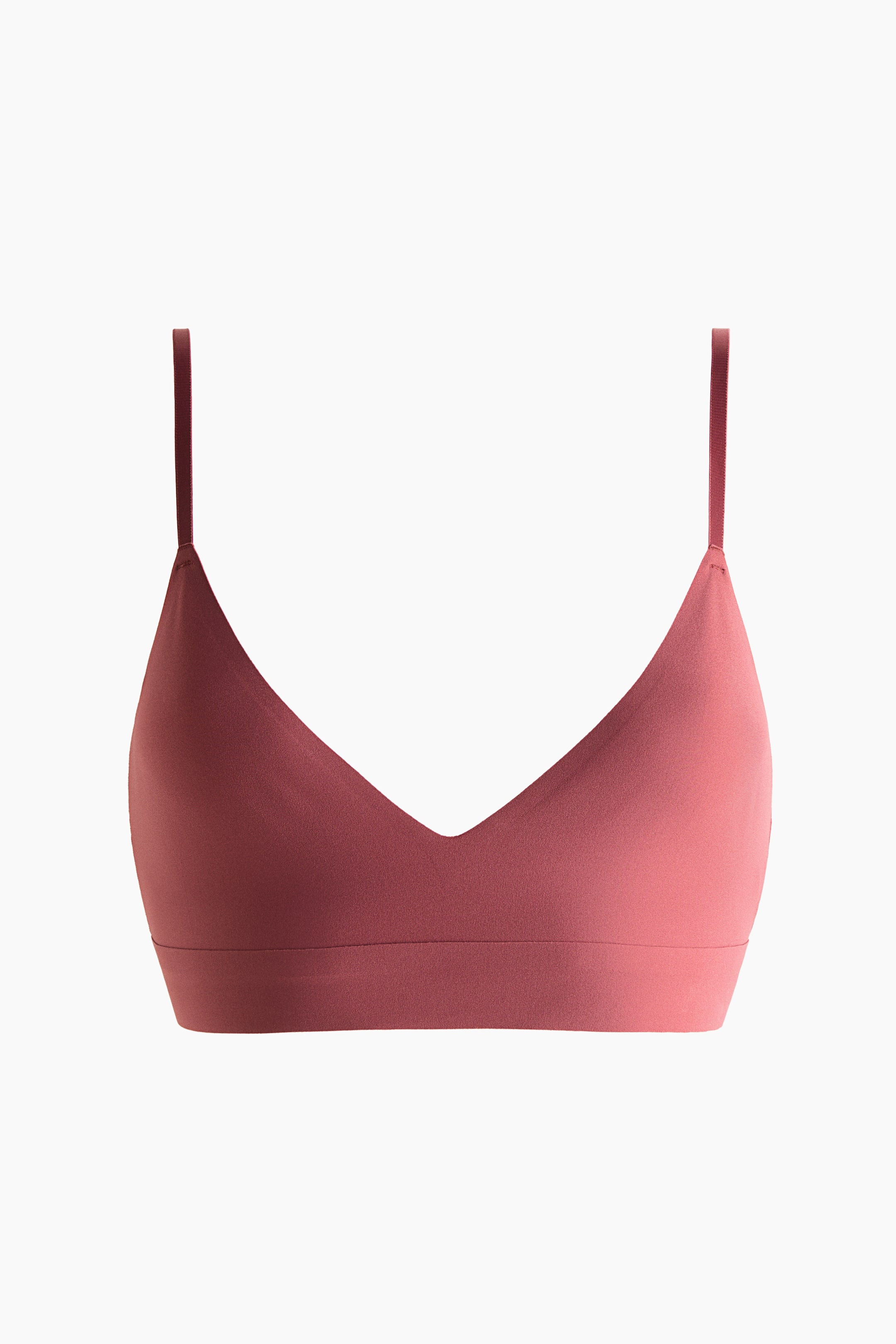 Grotere afbeelding bekijken: Een gedempte rozenroze driehoekige bralette is naar voren gericht. Het toont gladde, matte stof, dunne schouderbandjes, een diepe V-hals en een brede band aan de basis.