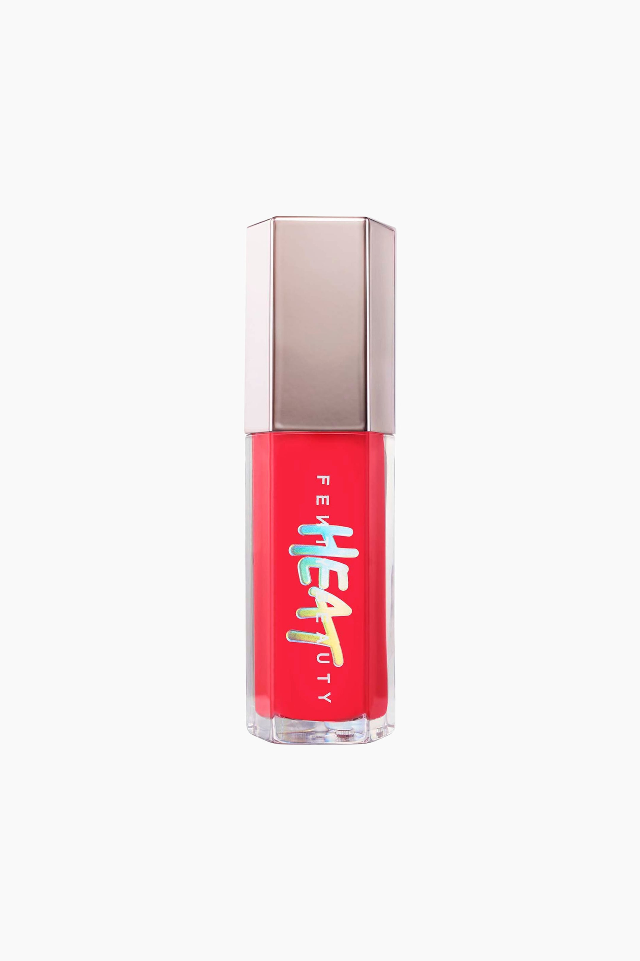 Visa större bild: Gloss Bomb Heat Universal Lip Luminizer + Plumper står upprätt och visar en genomskinlig hexagonal tub fylld med ett livfullt rött gloss och med ett metalliskt roséguldfärgat hexagonalt lock. På tubens framsida syns ordet "FENTY" i vita vertikala bokstäver, överlagt med en holografisk, stiliserad "HEAT"-logotyp.