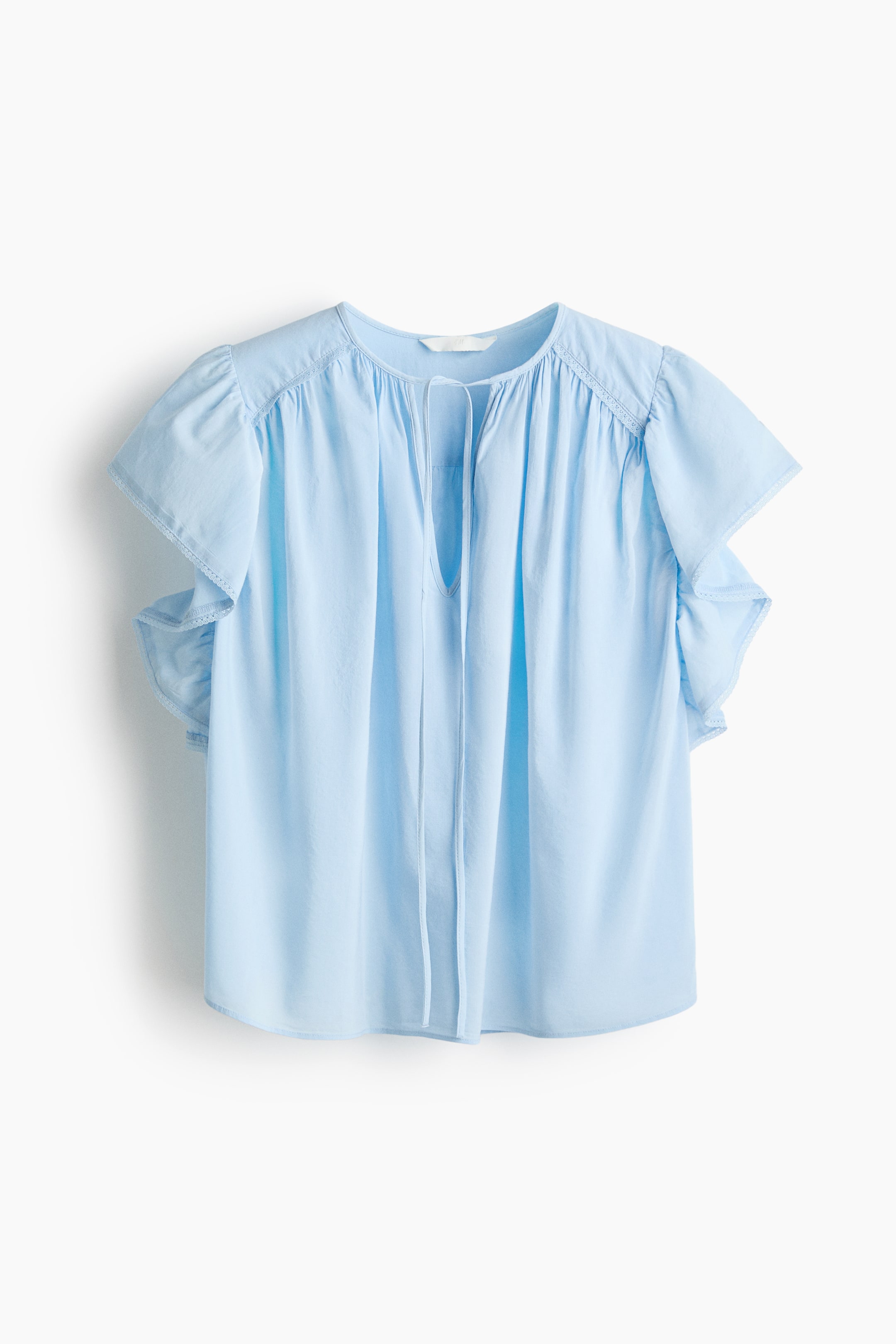 View larger image: An oversized light blue blouse is shown from the front, featuring a round neckline with narrow ties forming a V-shaped opening. It showcases voluminous flutter sleeves with delicate lace trim at the cuffs and gathers radiating from the neckline and shoulders.
