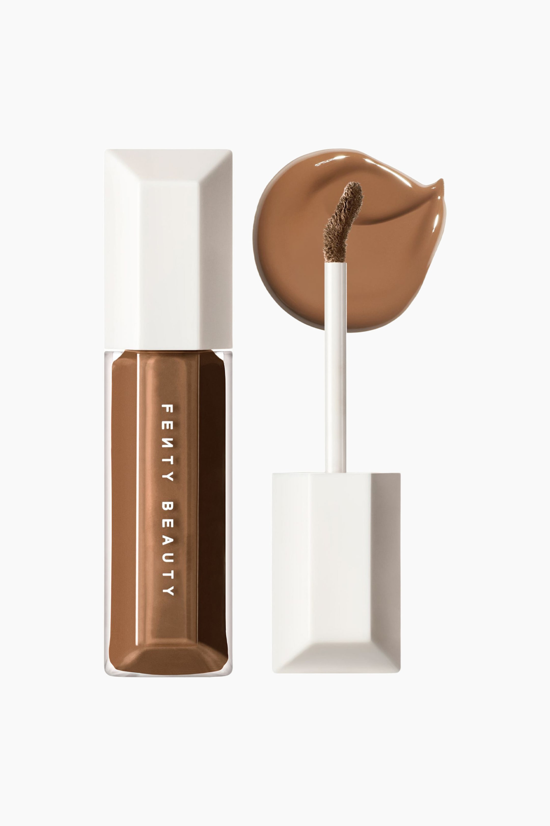 Visa större bild: We're Even Hydrating Longwear Concealer står upprätt i en genomskinlig, facetterad tub som visar en fyllig brun flytande formula och ett vitt geometriskt lock med vertikal "FENTY BEAUTY"-märkning. Bredvid tuben står applikatorn lodrätt med sin doe-foot-spets riktad mot en jämn, cirkelformad utstrykning av den matchande bruna concealern.