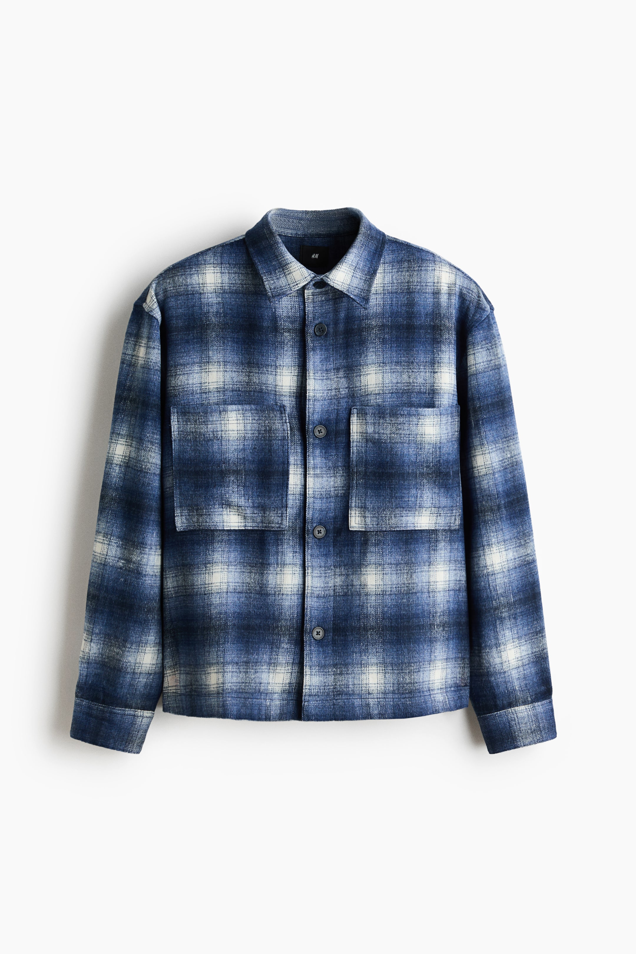 View larger image: A blue and white plaid overshirt showcasing a point collar and a button-up front closure. It features two large, buttoned chest patch pockets and long sleeves with buttoned cuffs.