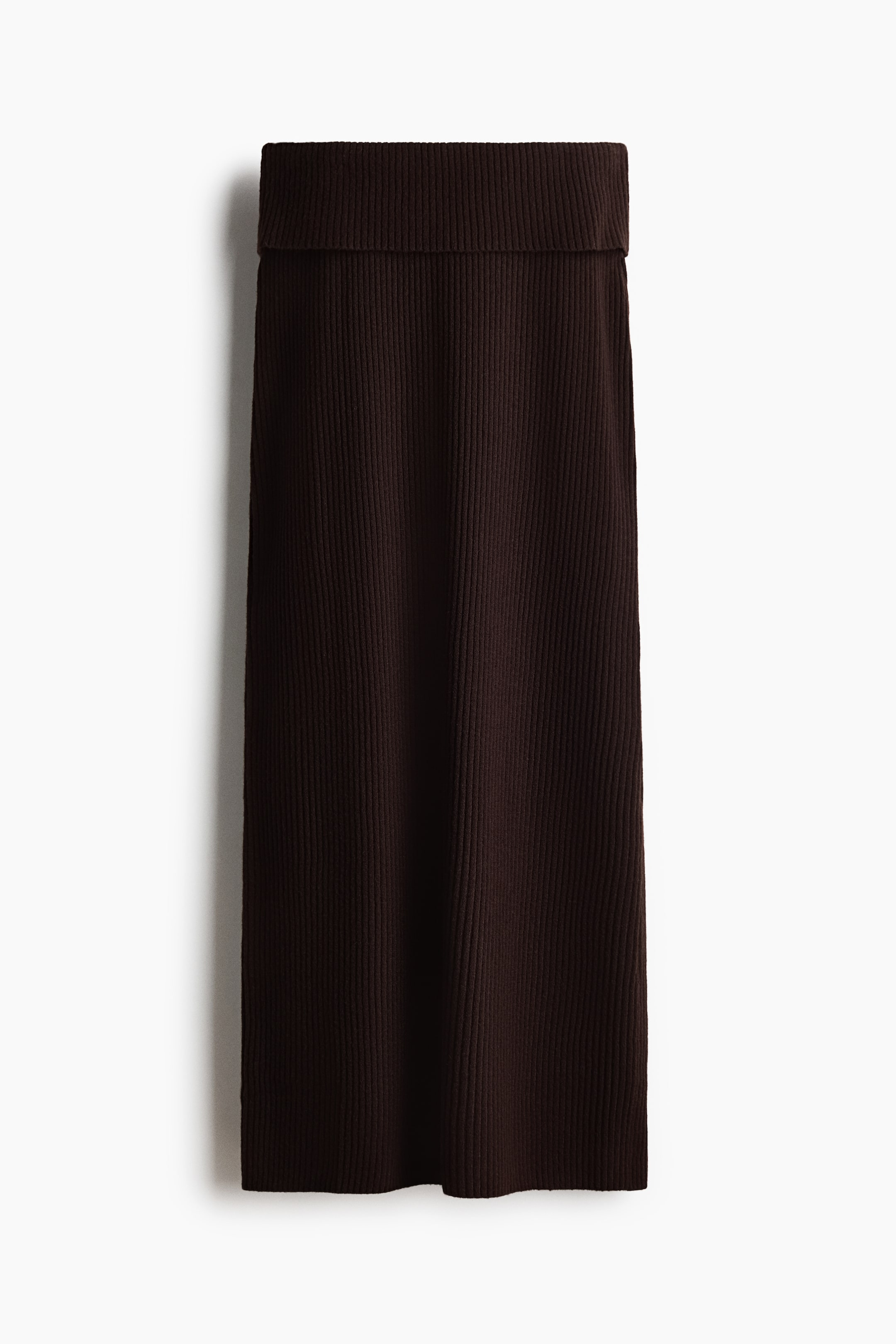 View larger image: "Sebuah skirt midi berwarna coklat gelap dengan tekstur ribbed menghadap depan, menampilkan pinggang ribbed lebar yang dilipat dan siluet lurus."