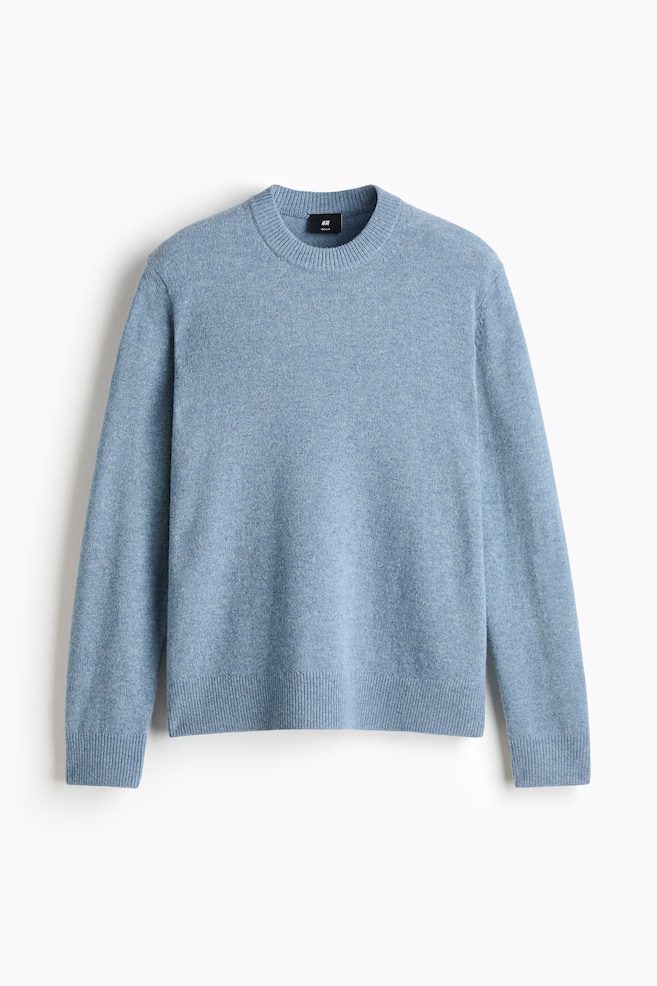 A light blue knitted wool jumper is shown from the front, featuring a round, rib-trimmed neckline and long sleeves. The design displays ribbed cuffs and a matching ribbed hem, highlighting a soft texture and a classic, regular-fit silhouette. - 1