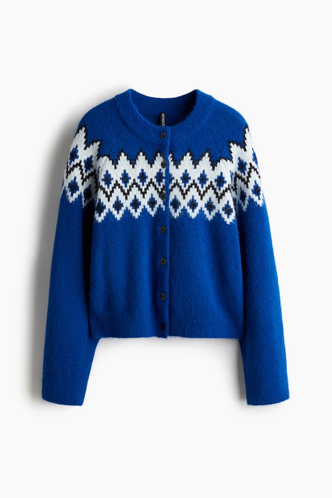 FRONTE: Viene presentato un cardigan blu, caratterizzato da un motivo fair isle bianco, nero e azzurro sul petto e sulle spalle. È progettato con un collo rotondo e una chiusura frontale con bottoni scuri. - 1