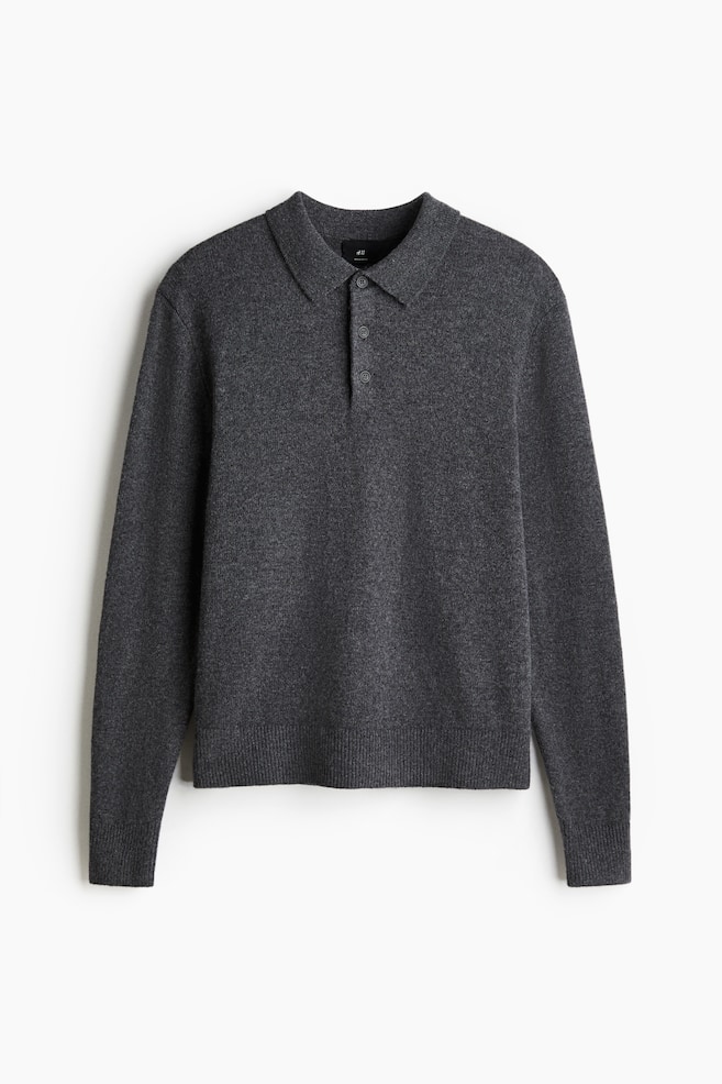 Un tricou polo gri închis este orientat spre față și este realizat dintr-un tricot de lână moale. Acesta are un guler, o plachetă cu trei nasturi și mâneci lungi cu manșete și tiv fin ribate. - 1