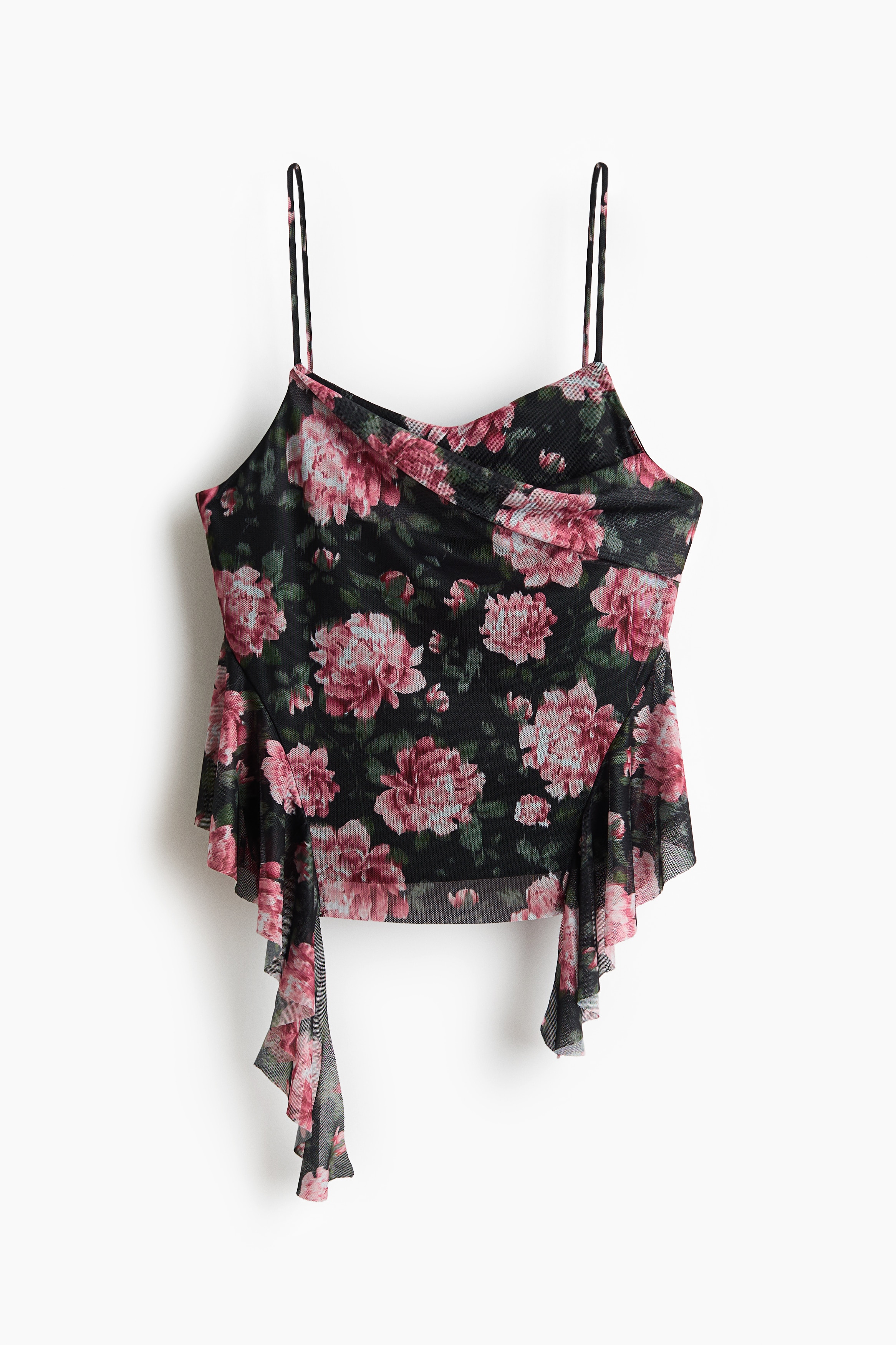 A sheer mesh camisole in a dark floral print is being worn by the model, paired with black shorts. The top features spaghetti straps, an asymmetrical foldover front, and draped, flounced panels cascading down the sides.