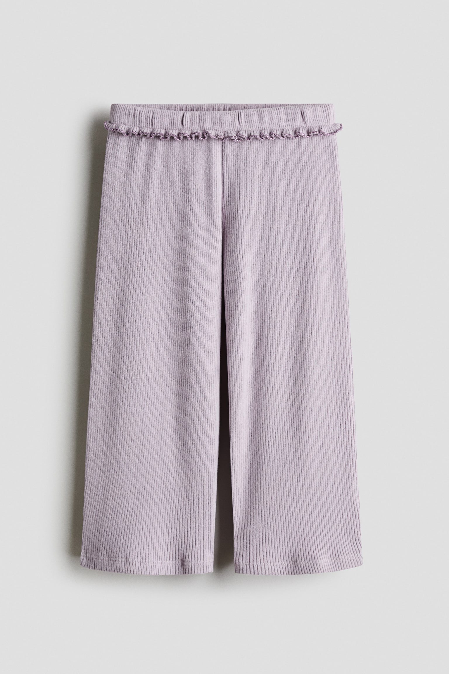 Lichtpaarse wijde broek in vooraanzicht, met een verticale ribstructuur en een elastische tailleband afgewerkt met een kleine ruche. De broek valt recht naar beneden en toont een losse pasvorm met wijde pijpen.