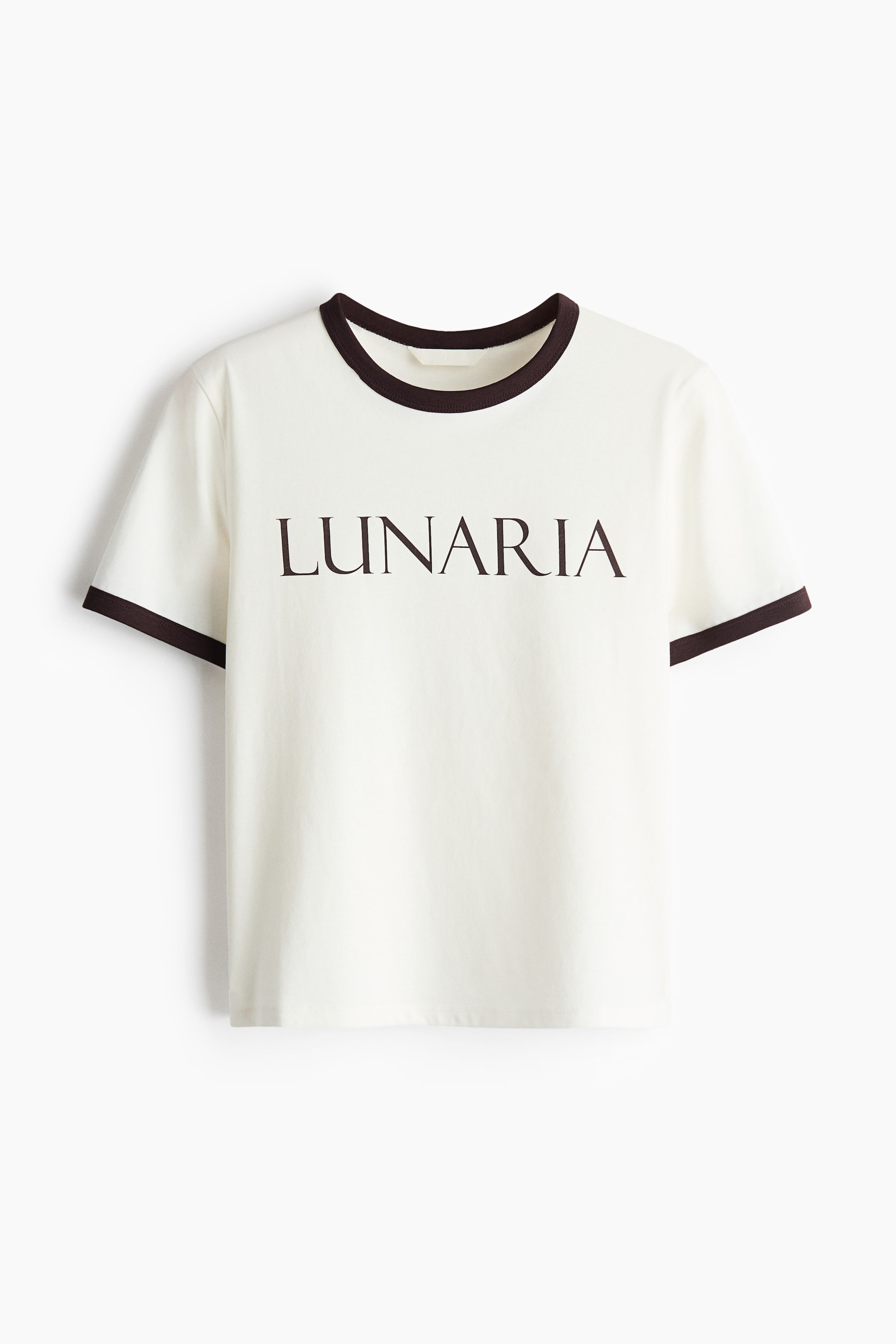 View larger image: The cream-coloured ringer t-shirt is showcased from the front, highlighting a dark brown trim on the crew neckline and short sleeve cuffs. The word "LUNARIA" is emblazoned across the chest in dark brown capital letters.