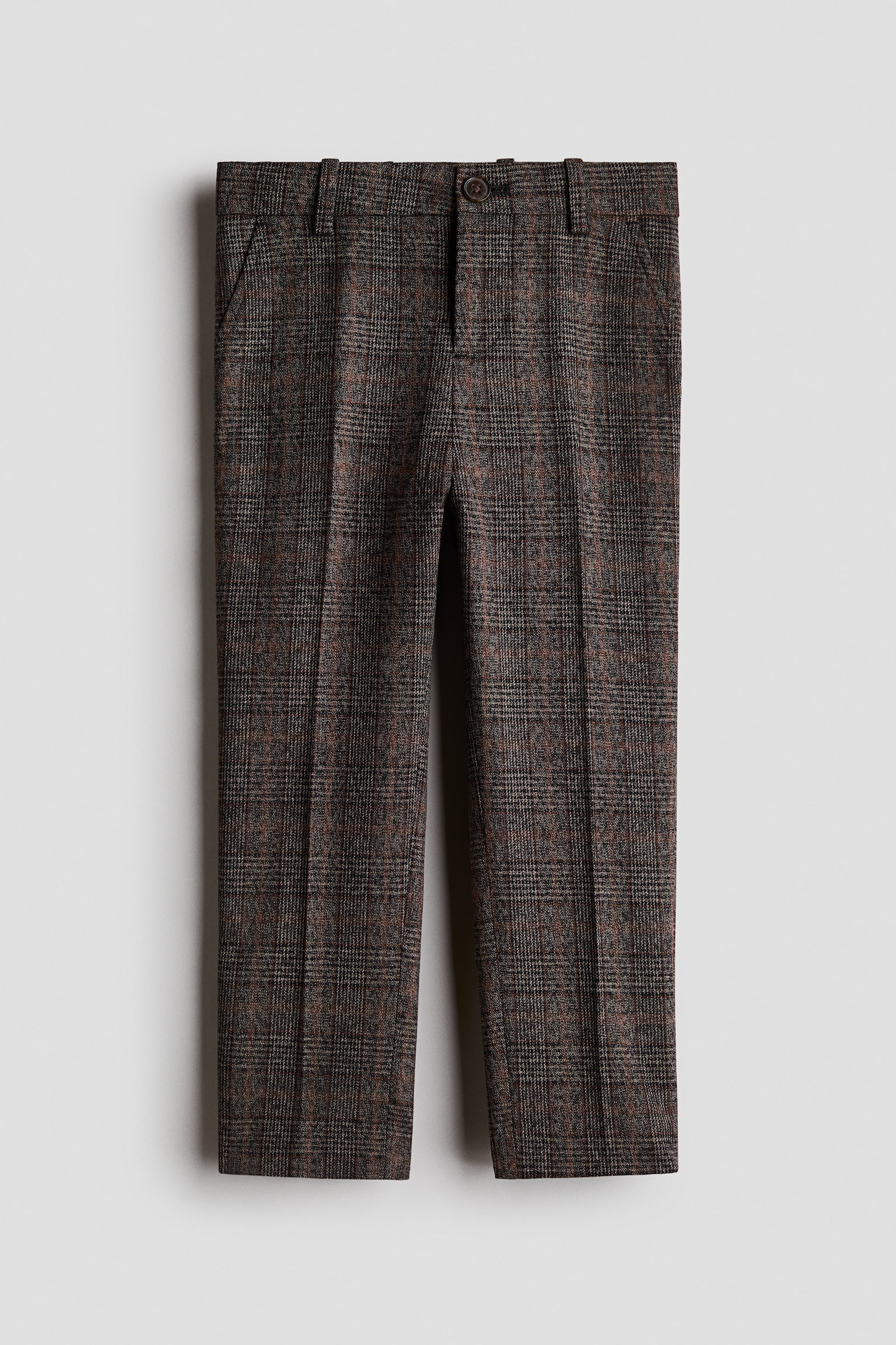 A front view showing slim-fit suit trousers in a brown and grey plaid cotton weave, featuring a button closure at the waistband, side pockets, and sharp creases running down the centre of each leg.