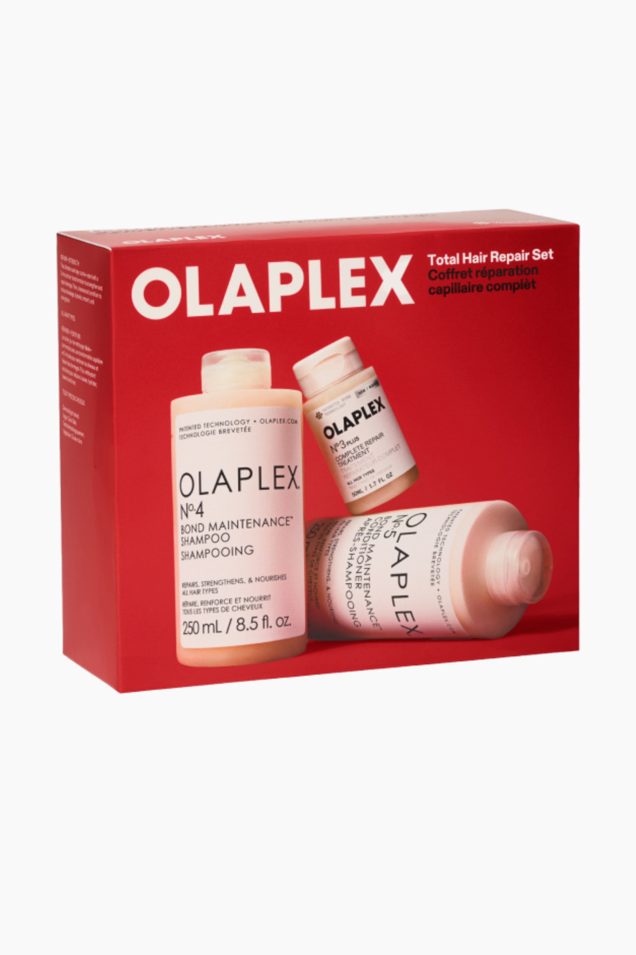 Visa större bild: Olaplex Total Hair Repair Set presenteras i en rektangulär röd låda, vinklad något åt vänster för att visa dess fram- och sidopaneler. Förpackningens framsida visar den vita Olaplex-logotypen tillsammans med bilder av flaskorna med No. 4 Bond Maintenance Shampoo, No. 3 Complete Repair Treatment och No. 5 Bond Maintenance Conditioner.