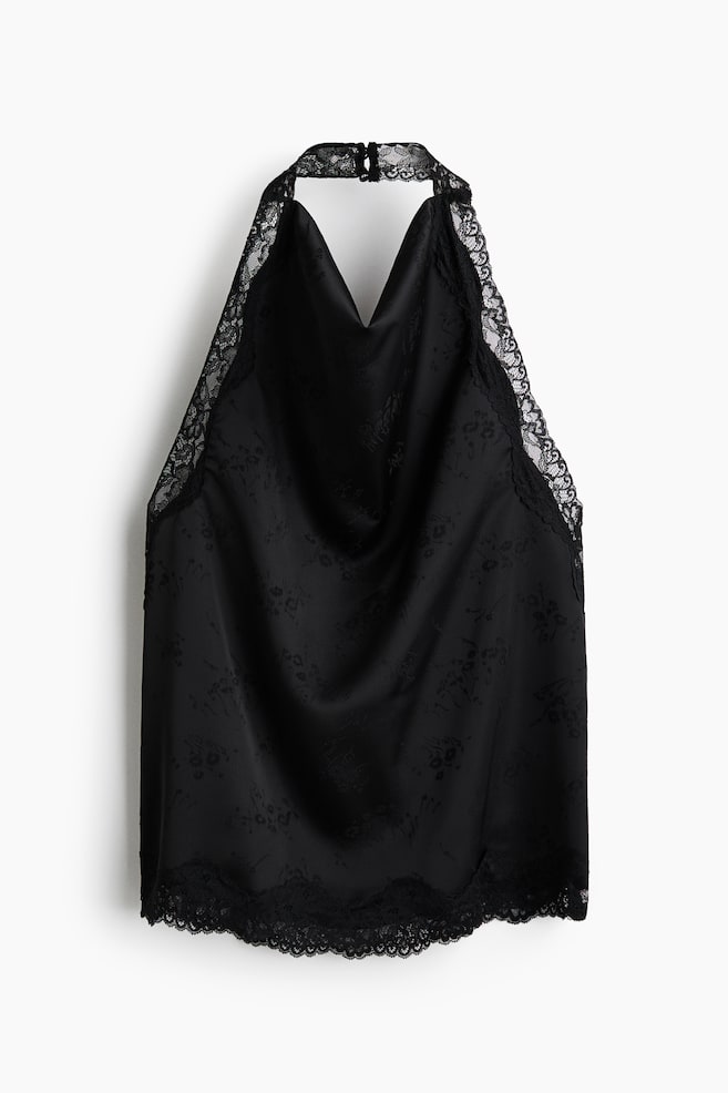 Un haut licou noir est prÃ©sentÃ© de face, mettant en valeur un dÃ©colletÃ© drapÃ© Ã  col bÃ©nitier en tissu jacquard satinÃ© avec un subtil motif floral. Une dÃ©licate dentelle noire borde le col montant licou ainsi que lâourlet infÃ©rieur festonnÃ©. - 1