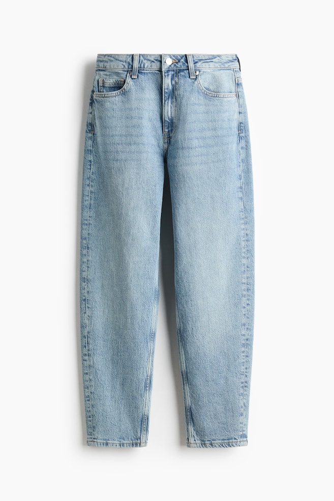 A pair of light-wash blue jeans is shown from the front, featuring a relaxed, tapered-leg silhouette with subtle fading down the front of the legs. The jeans display a classic five-pocket design, belt loops, and a single silver-tone button fastening at the waistband. - 1