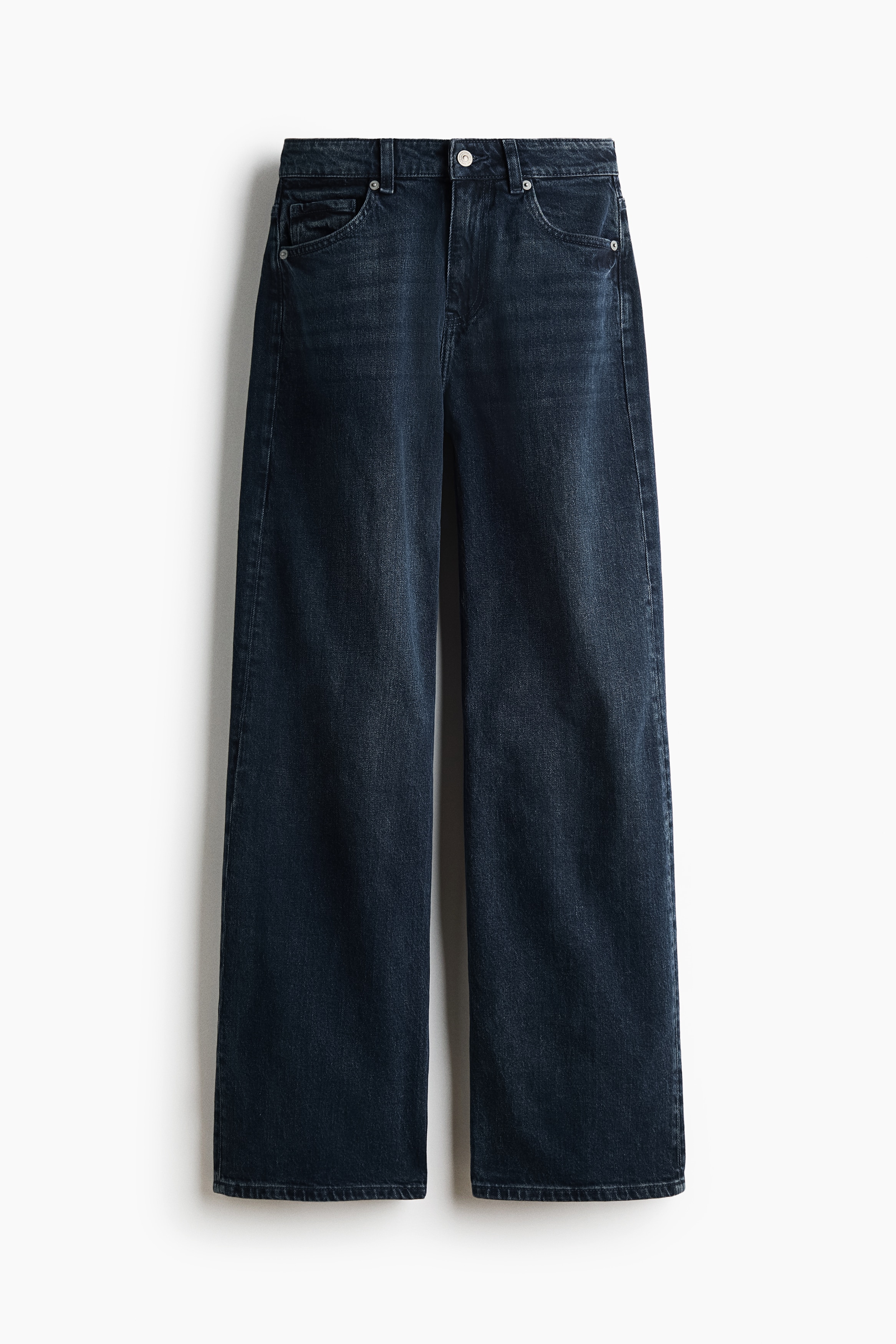 Dark-wash denim jeans featuring a high waist and a loose, straight-leg cut are worn by the model. The model is lifting the hem of a striped long-sleeve top with one hand, revealing the waistband of the jeans.