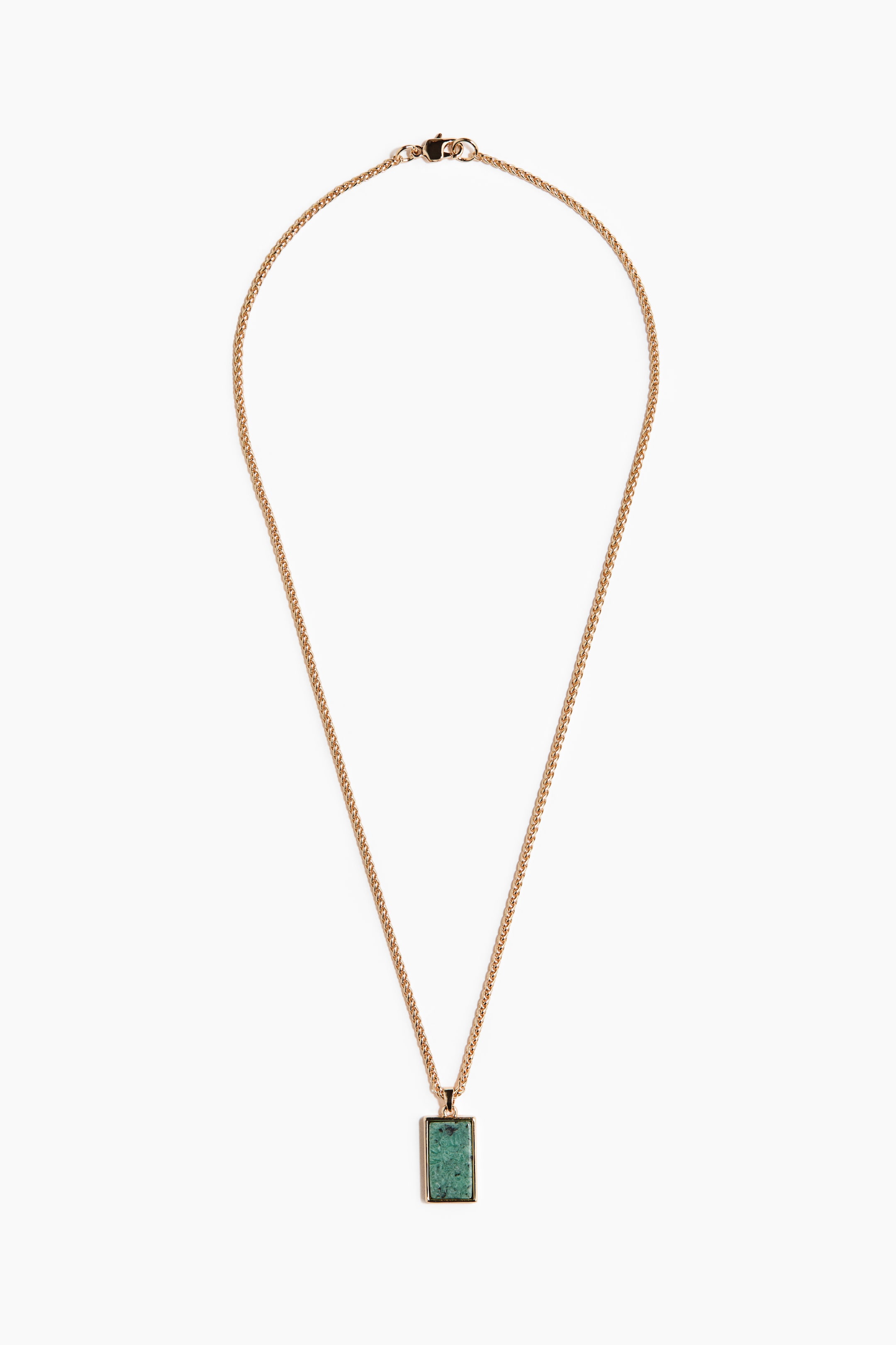 View larger image: A gold-toned necklace featuring a rectangular pendant with a textured green stone, positioned at the bottom centre. The thin chain is showing a lobster clasp at the top.
