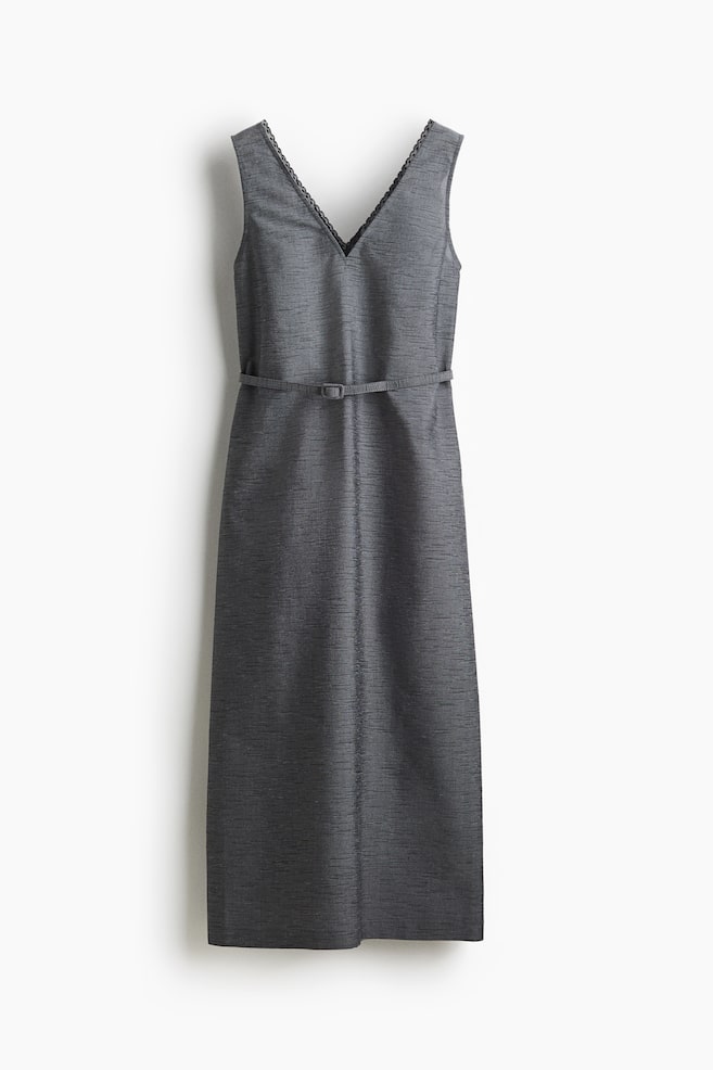 A front-facing charcoal gray sleeveless midi dress is displaying a subtle textured weave. Its V-neckline is trimmed with black lace, and a thin self-fabric belt with a rectangular buckle is cinching the waist. - 1