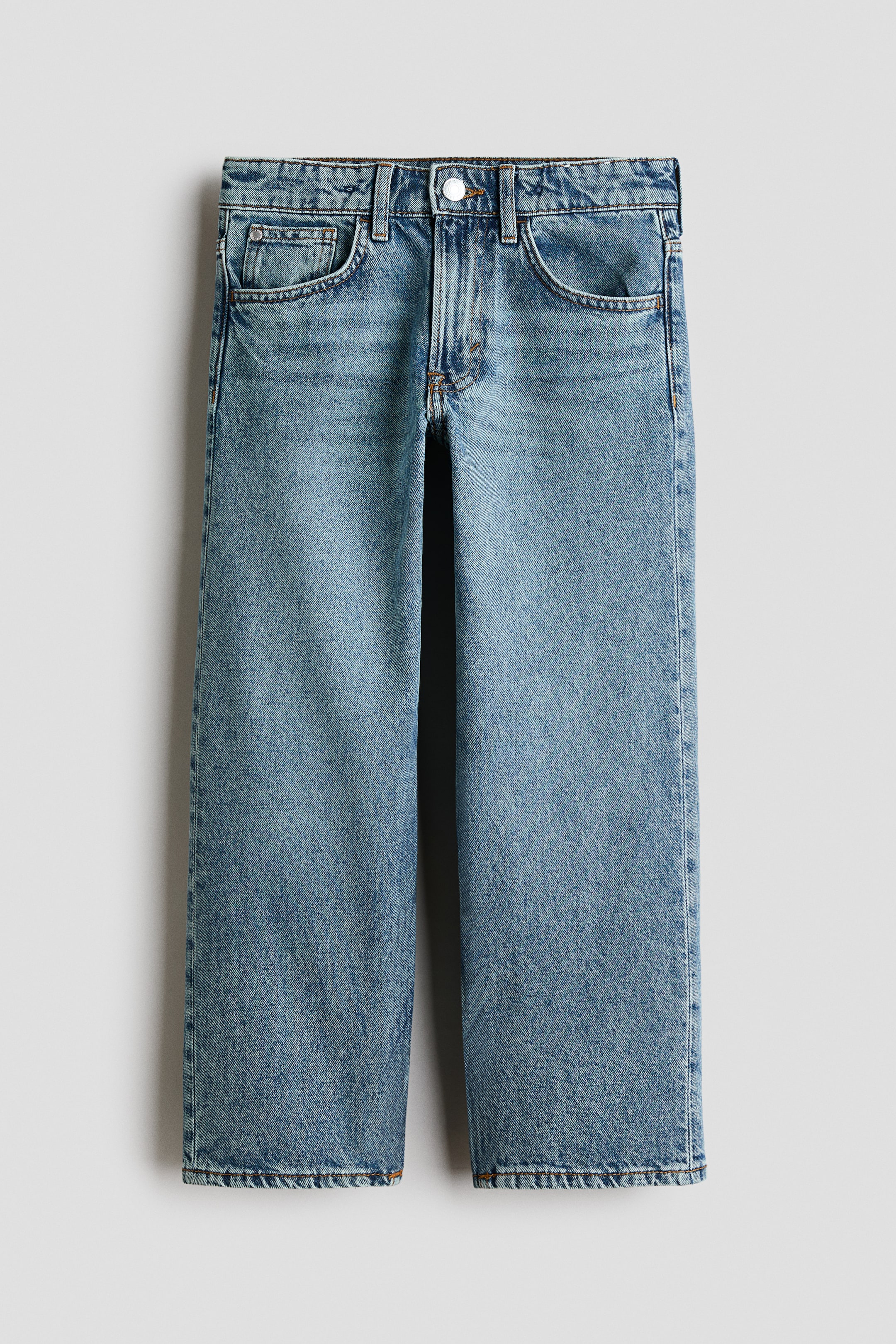 Agrandir l'image: Un jean à 5 poches, coupe ample, en denim de coton bleu clair délavé est présenté de face. Il est doté d'une taille élastiquée ajustable, d'une fermeture à bouton avec braguette zippée, et de jambes droites.