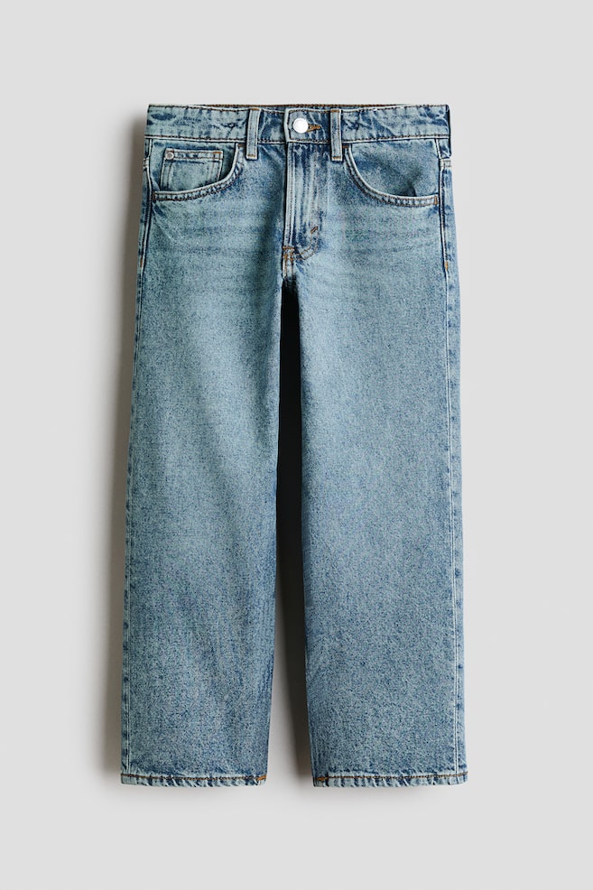 A pair of 5-pocket, loose-fit jeans in a light blue washed cotton denim is showcased from the front. They feature adjustable elastication at the waist, a button fastening with a zip fly, and straight legs. - 1