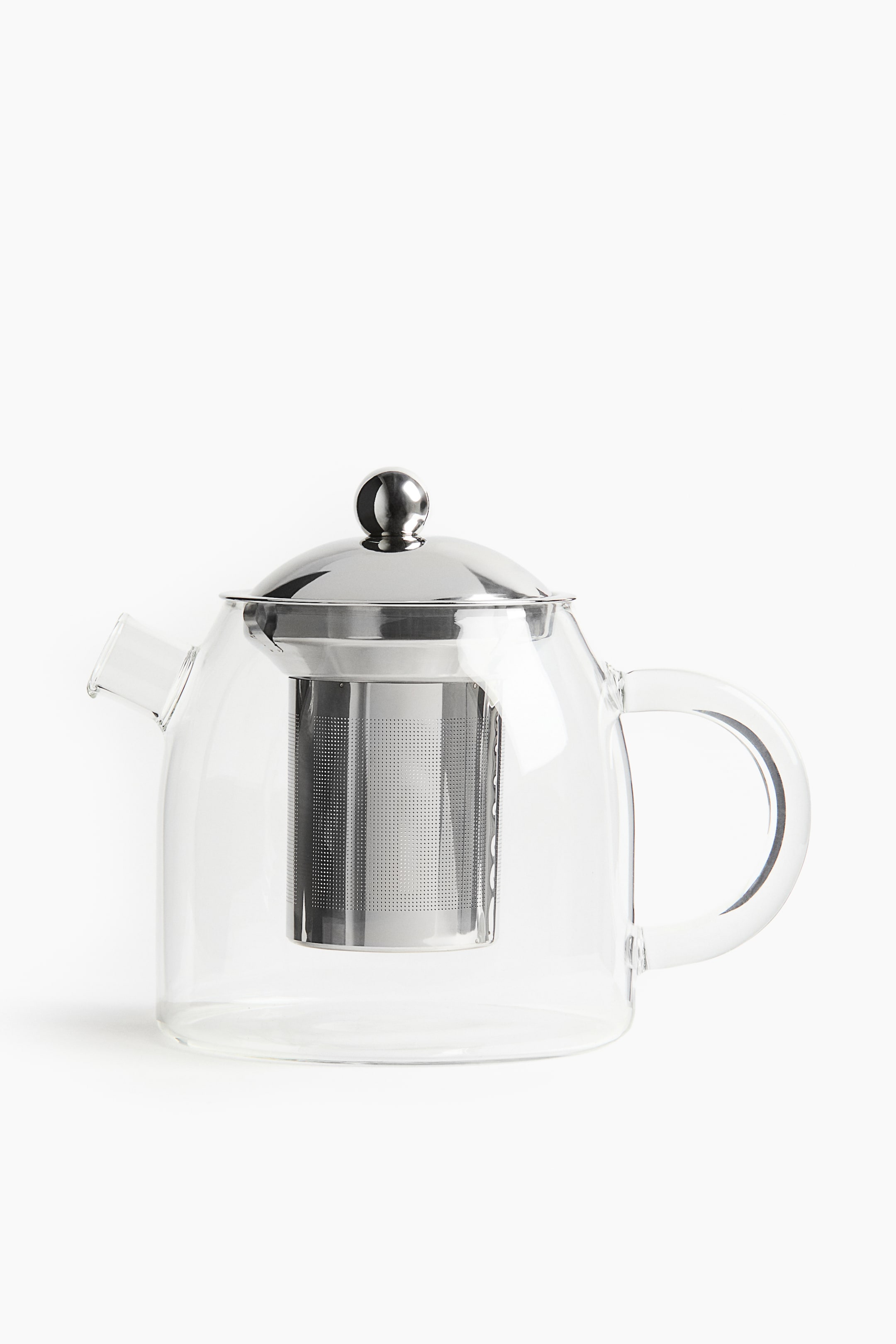 View larger image: A clear glass teapot is positioned FRONT, featuring a domed stainless steel lid with a spherical knob, a cylindrical perforated stainless steel infuser suspended inside, a clear glass handle, and a pouring spout.