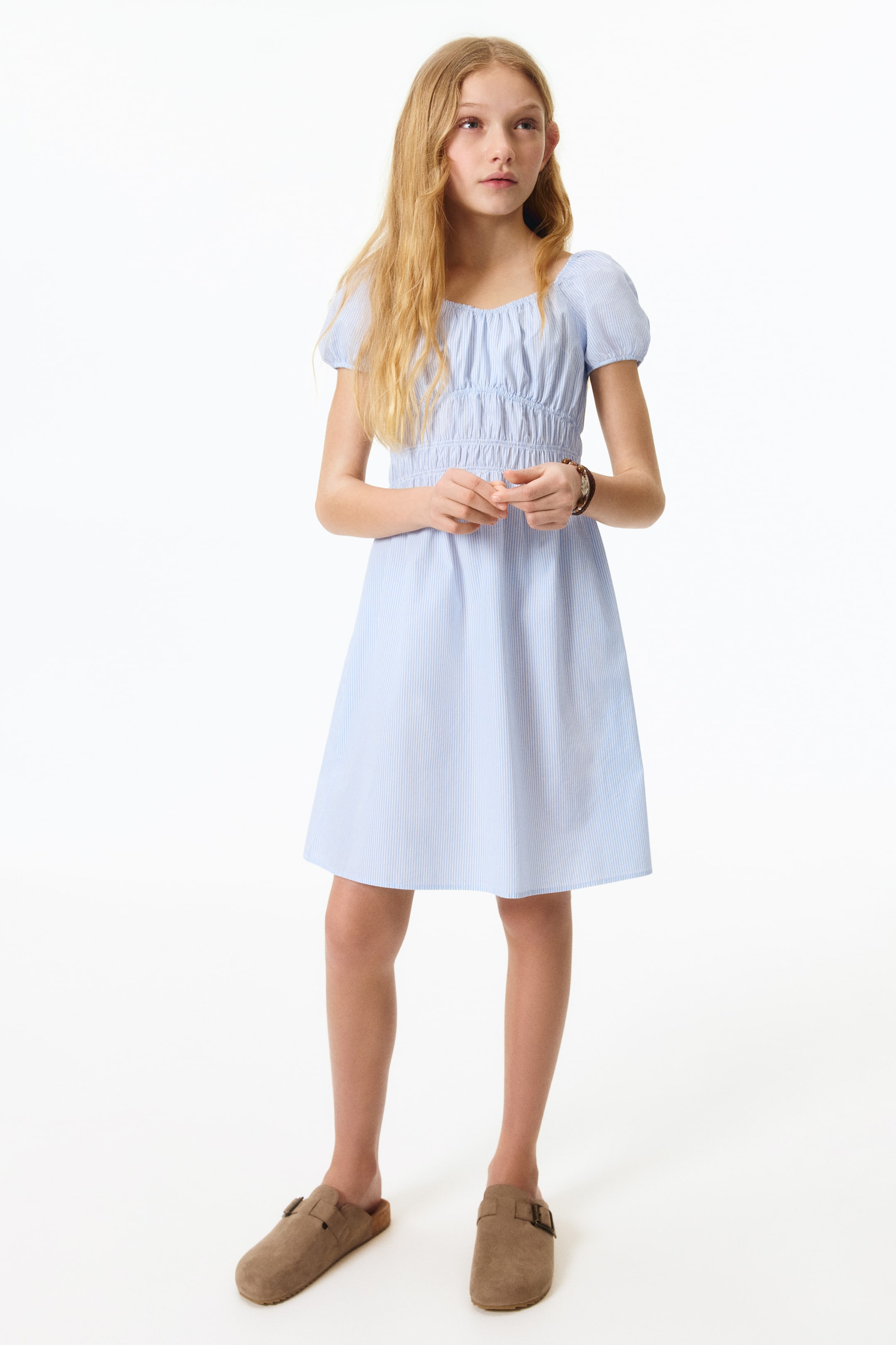 View larger image: A front-facing flared dress crafted from a breezy, striped cotton weave features an elasticated sweetheart neckline and short puff sleeves. Elasticated, gathered seams detail the waist, flowing into a flared skirt.