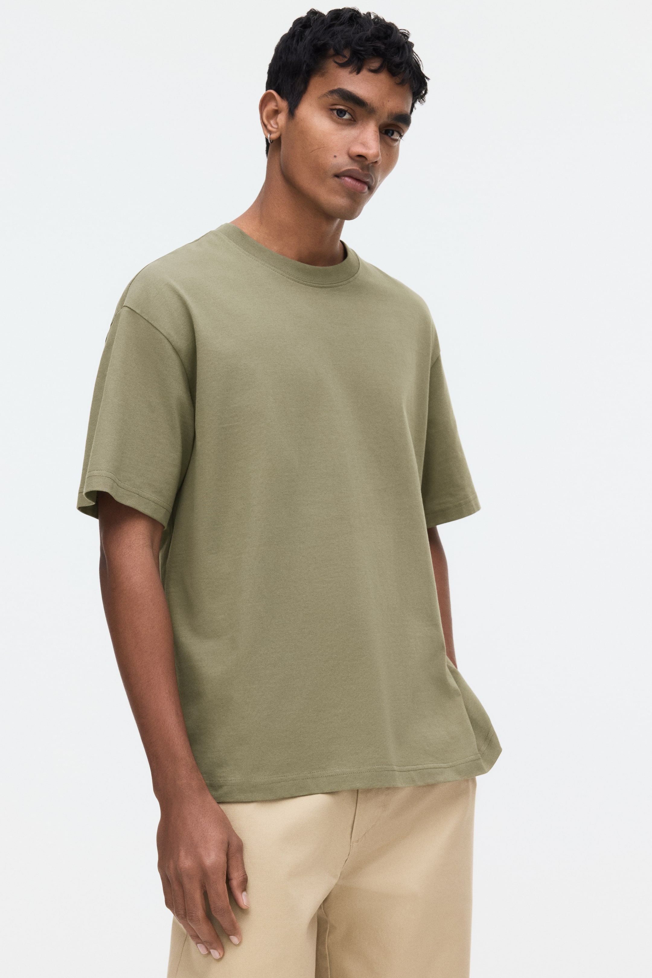 View larger image: An olive green crew neck t-shirt is shown facing forward, showcasing a relaxed fit with short, wide sleeves, a smooth fabric, and a straight hem.