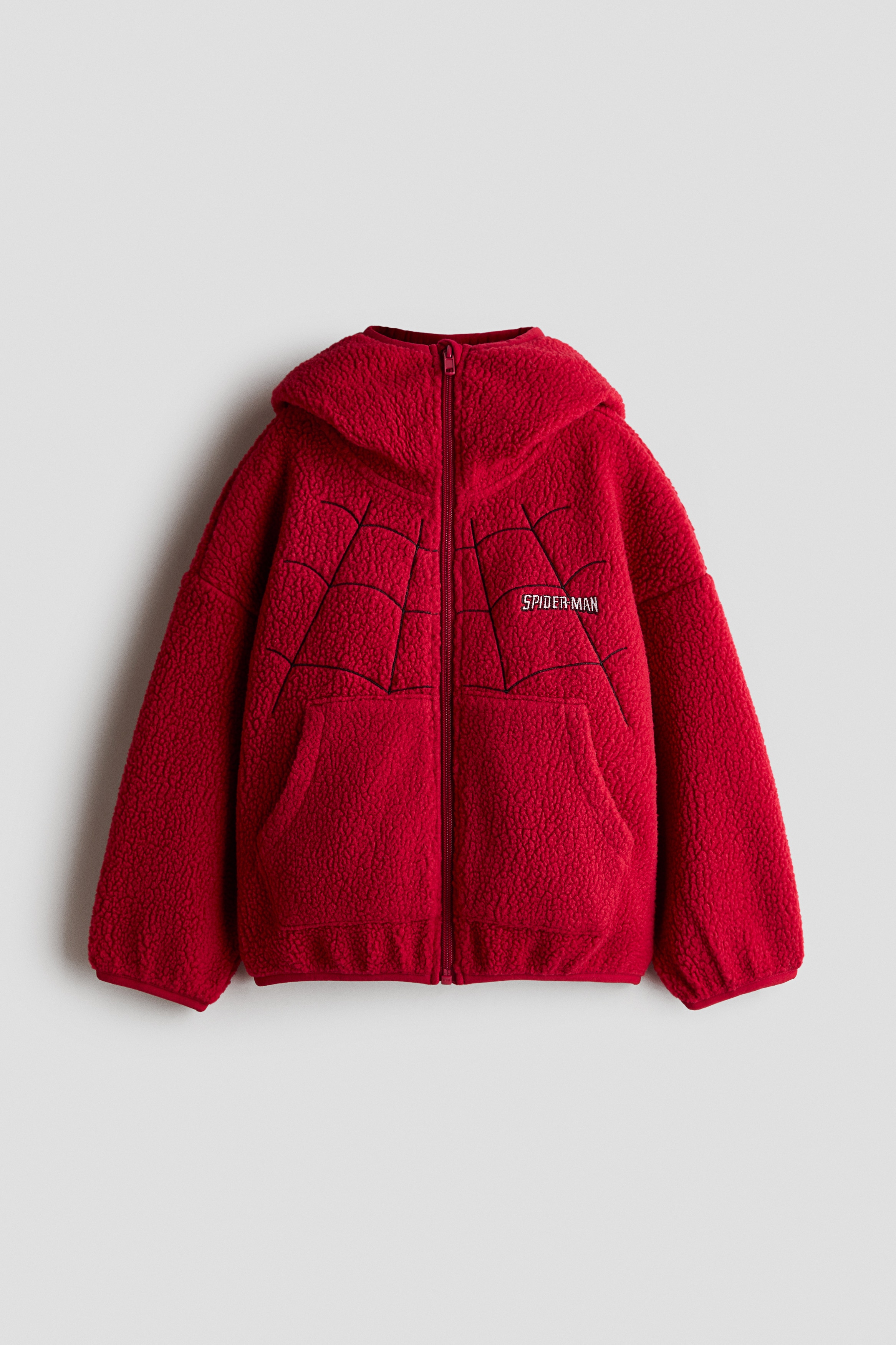 ëª¨ë¸ì´ ê°ì´ ë¶ë¶ì ìì ì²ë¦¬ë ê±°ë¯¸ì¤ ëíì¼ê³¼ íì¤í¸ ë¡ê³ ê° ë¤ì´ê° ë ë teddy fleece ì¬í·ì ì°©ì©íê³  ììµëë¤. íë ì¬í·ì ë¸ë£¨ ì§ê³¼ í¨ê» ì¤íì¼ë§ëìì¼ë©°, ëª¨ë¸ì ìì ìì£¼ë¨¸ëì ë£ì ì± ì ììµëë¤.