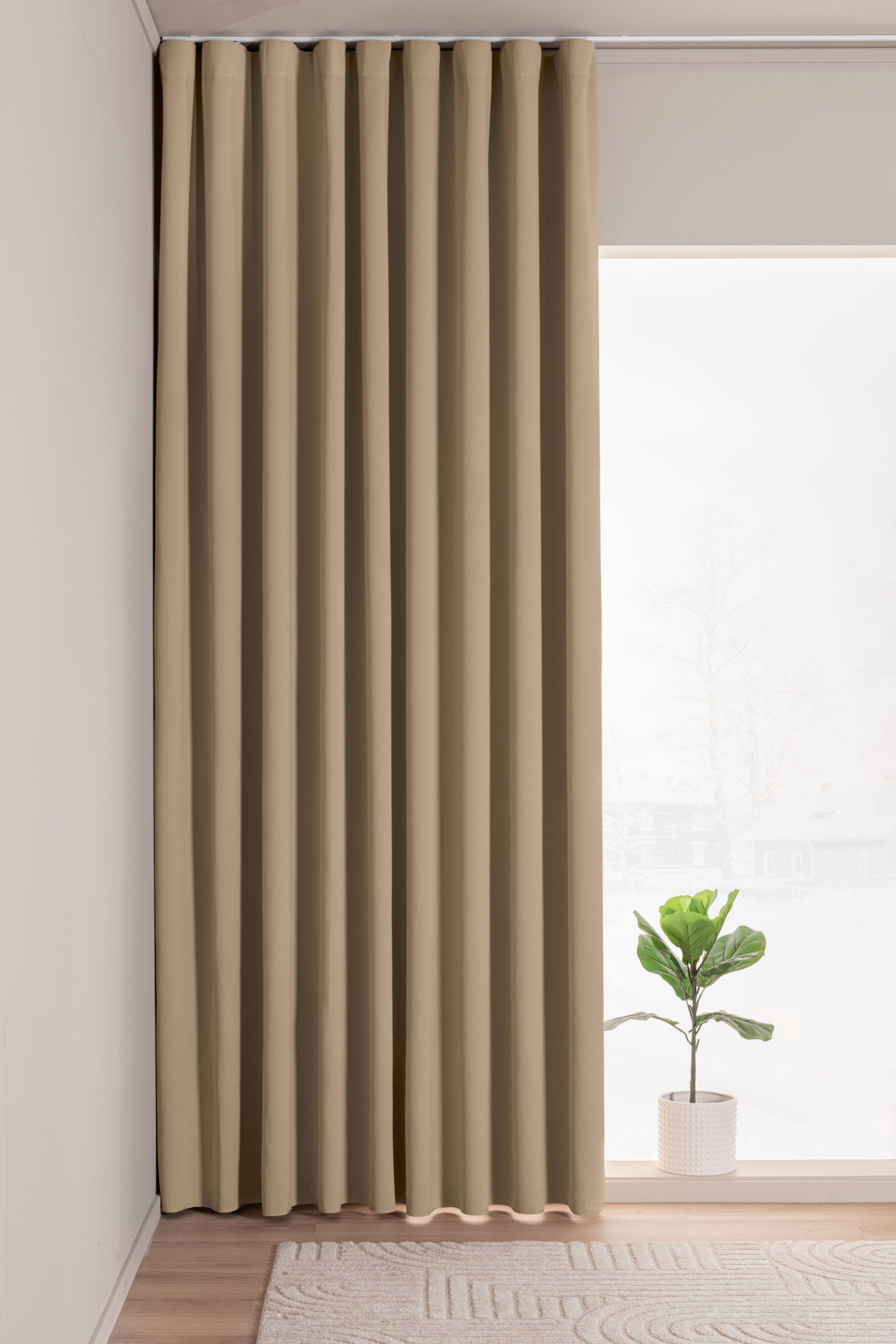 Visa större bild: En beige S-vik gardin hänger från en takskena och presenterar kontinuerliga, mjuka vertikala vågor. Den är helt utdragen och sträcker sig från taket till precis ovanför golvet.