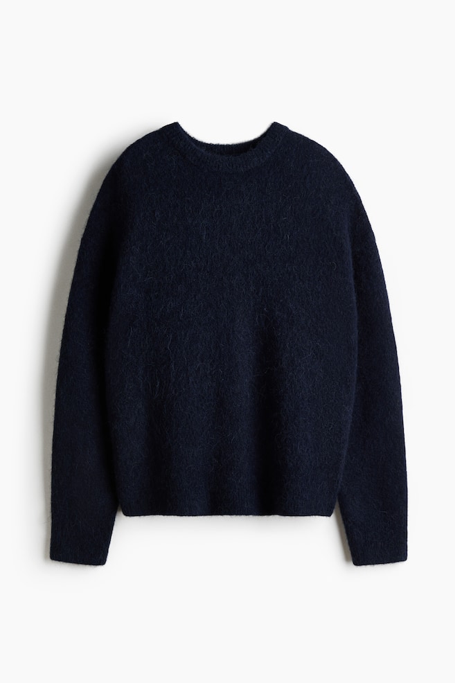 An oversized navy blue jumper in a soft, fuzzy knit is shown front-facing, showcasing a ribbed crew neck, dropped shoulders, and long sleeves with ribbed cuffs and a ribbed hem. - 1