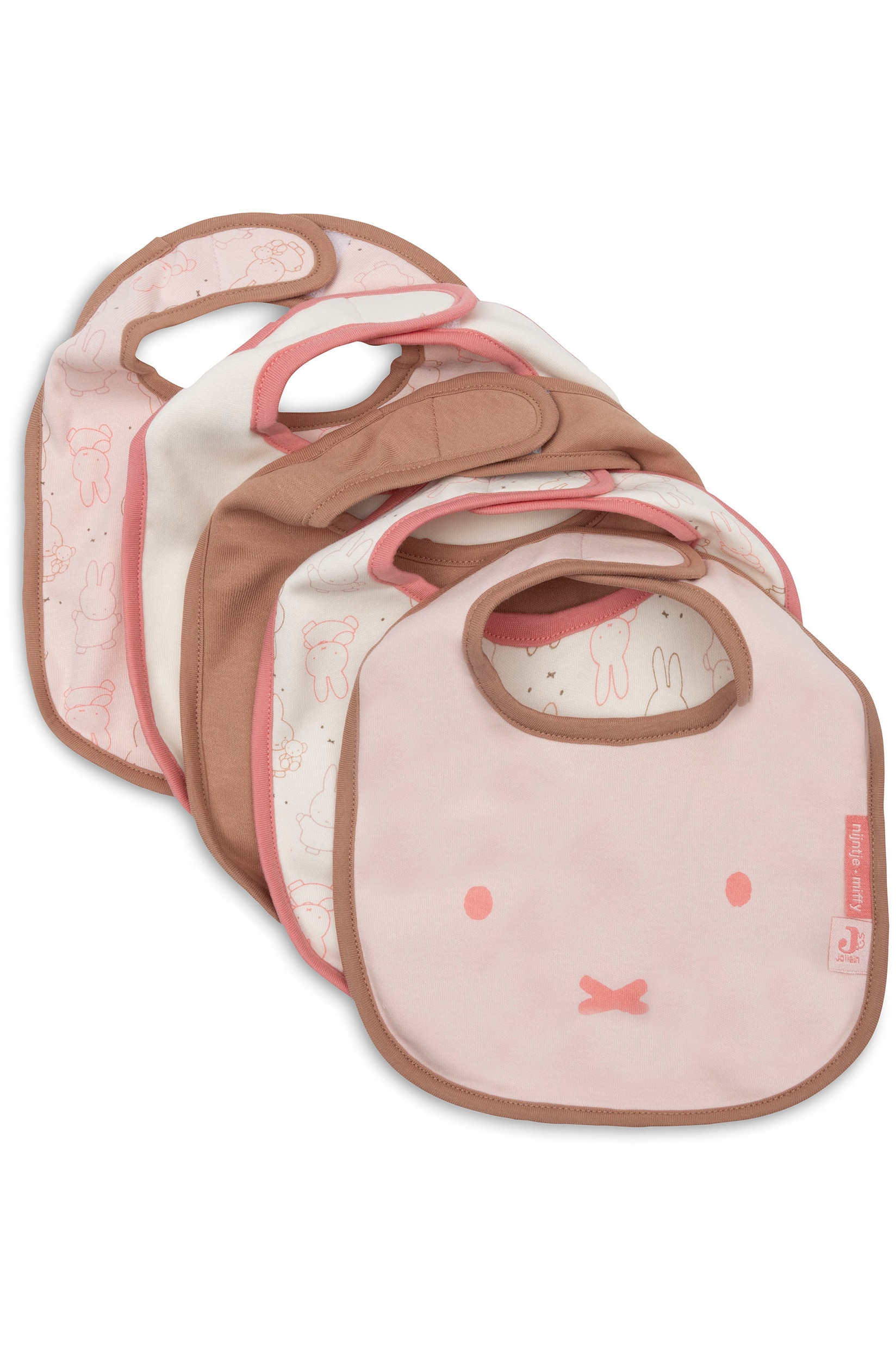 Een stapel baby bandana slabbetjes toont verschillende ontwerpen in tinten lichtroze, crÃ¨me en beige. De slabbetjes liggen overlappend om de contrasterende biesafwerking, kleine rode merklabels en patronen met silhouetten van figuren en effen kleuren te laten zien.