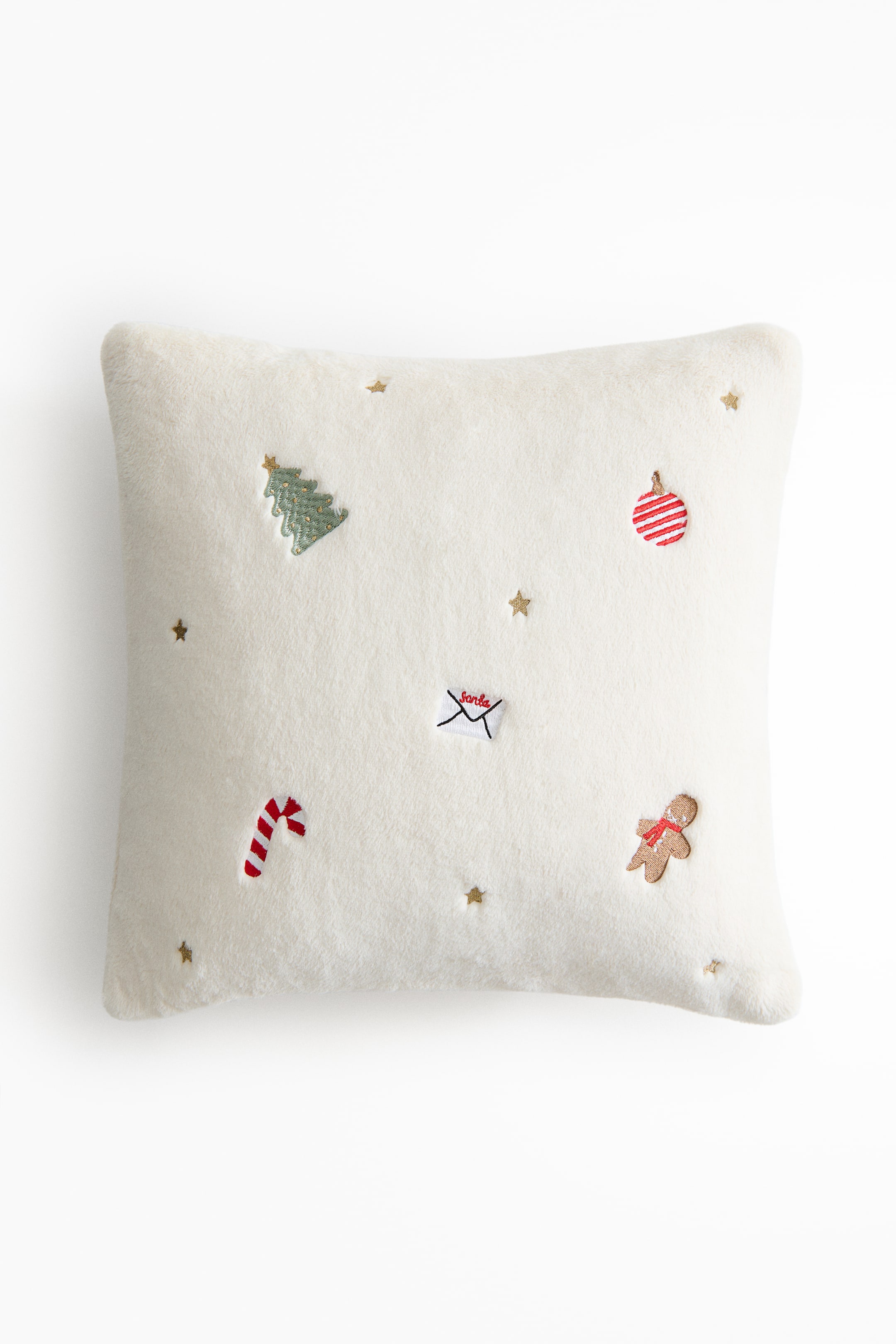 View larger image: A cushion cover is displayed from the front, featuring a soft off-white pile texture. It is detailed with embroidered motifs including a green Christmas tree, a red and white candy cane, a small envelope addressed 'Santa', a red and white striped ornament, a gingerbread man with a red scarf, and scattered gold stars.