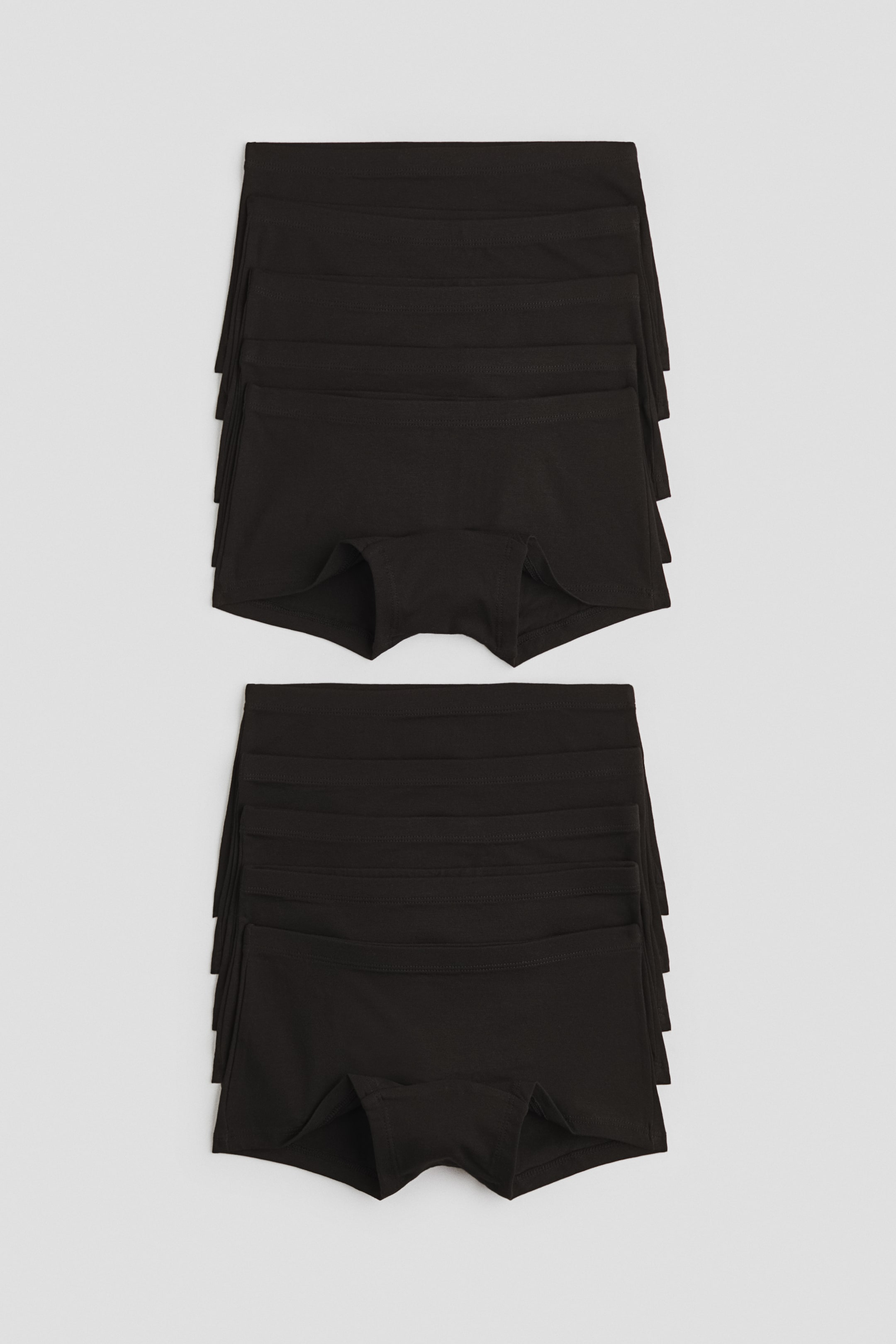 Visualizza immagine più grande: Slip boxer neri in morbido jersey di cotone sono presentati in due pile, ciascuna con una vita elasticizzata e un tassello foderato nel paio superiore rivolto verso l’alto.