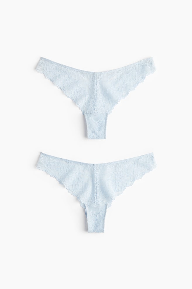 Two light blue lace briefs are lying flat, each presenting its FRONT. They are featuring a low, V-shaped waist and are designed with a high cut at the back. - 1