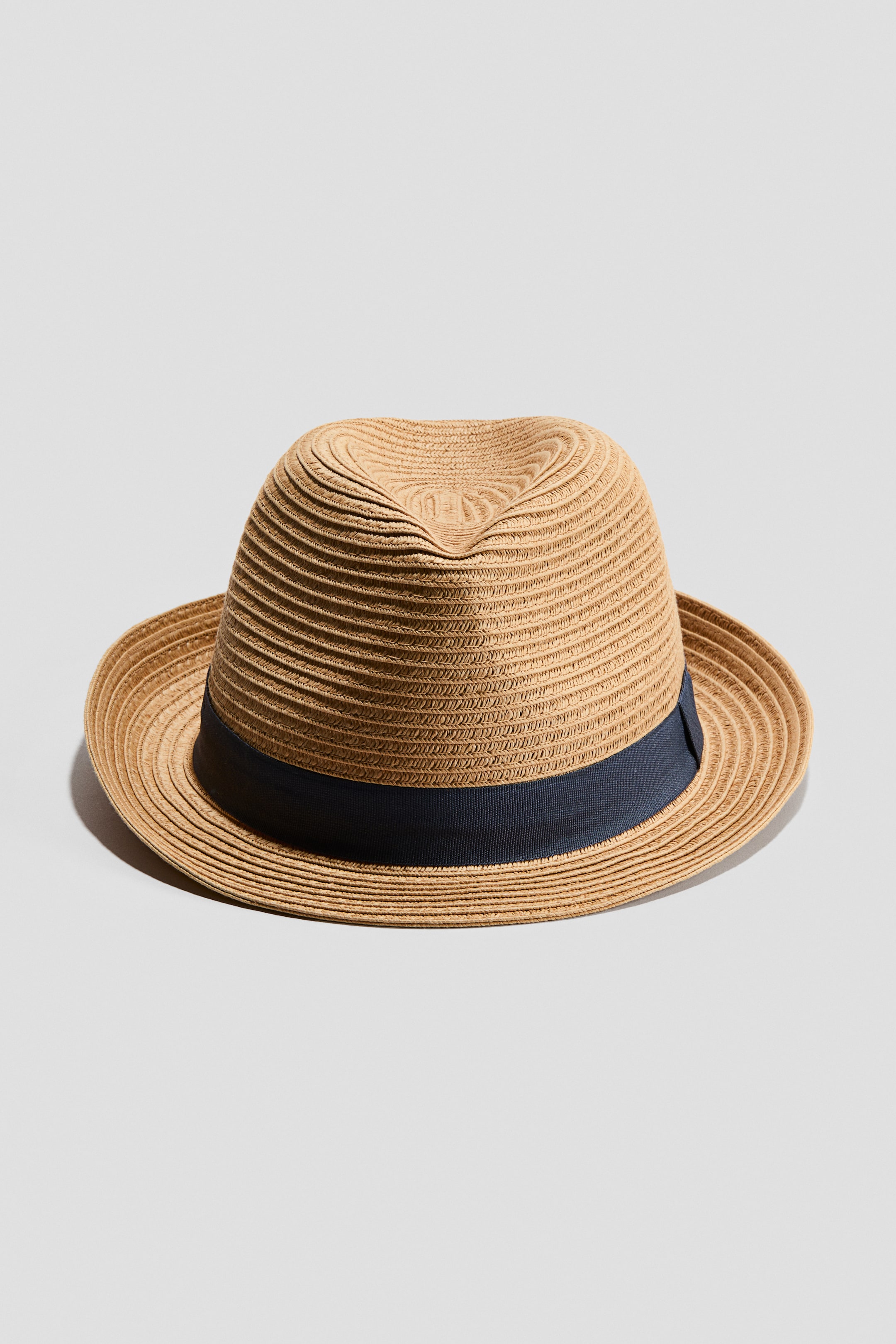 Ampliar la imagen: Un sombrero hecho de paja de papel trenzado se presenta desde el frente, con una corona hundida y una banda de grosgrain oscuro.
