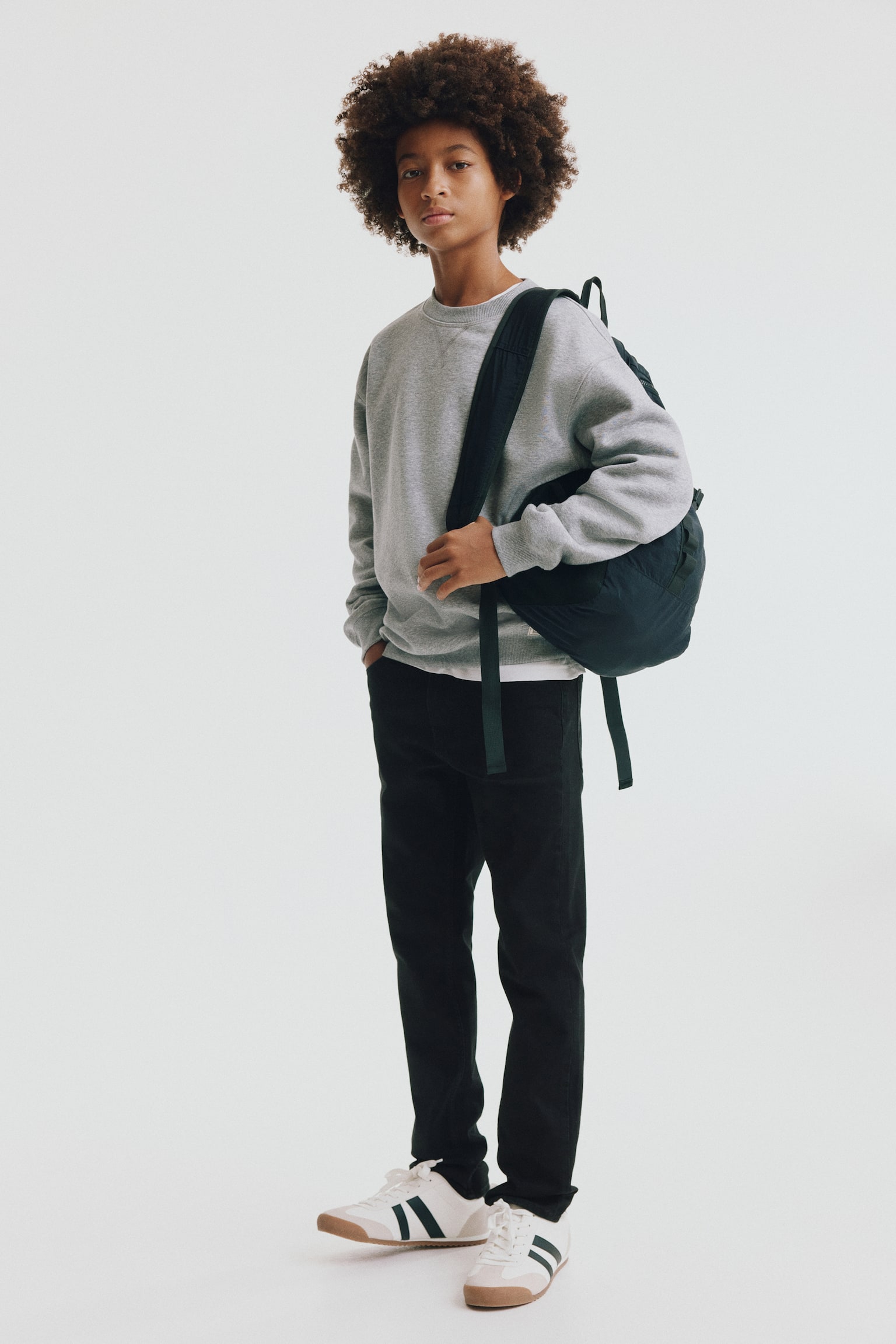 Black slim-fit jeans in washed denim are laid flat, facing forward. They feature a 5-pocket style with two front pockets and a coin pocket, a button closure with a zip fly, and straight hems. - 1