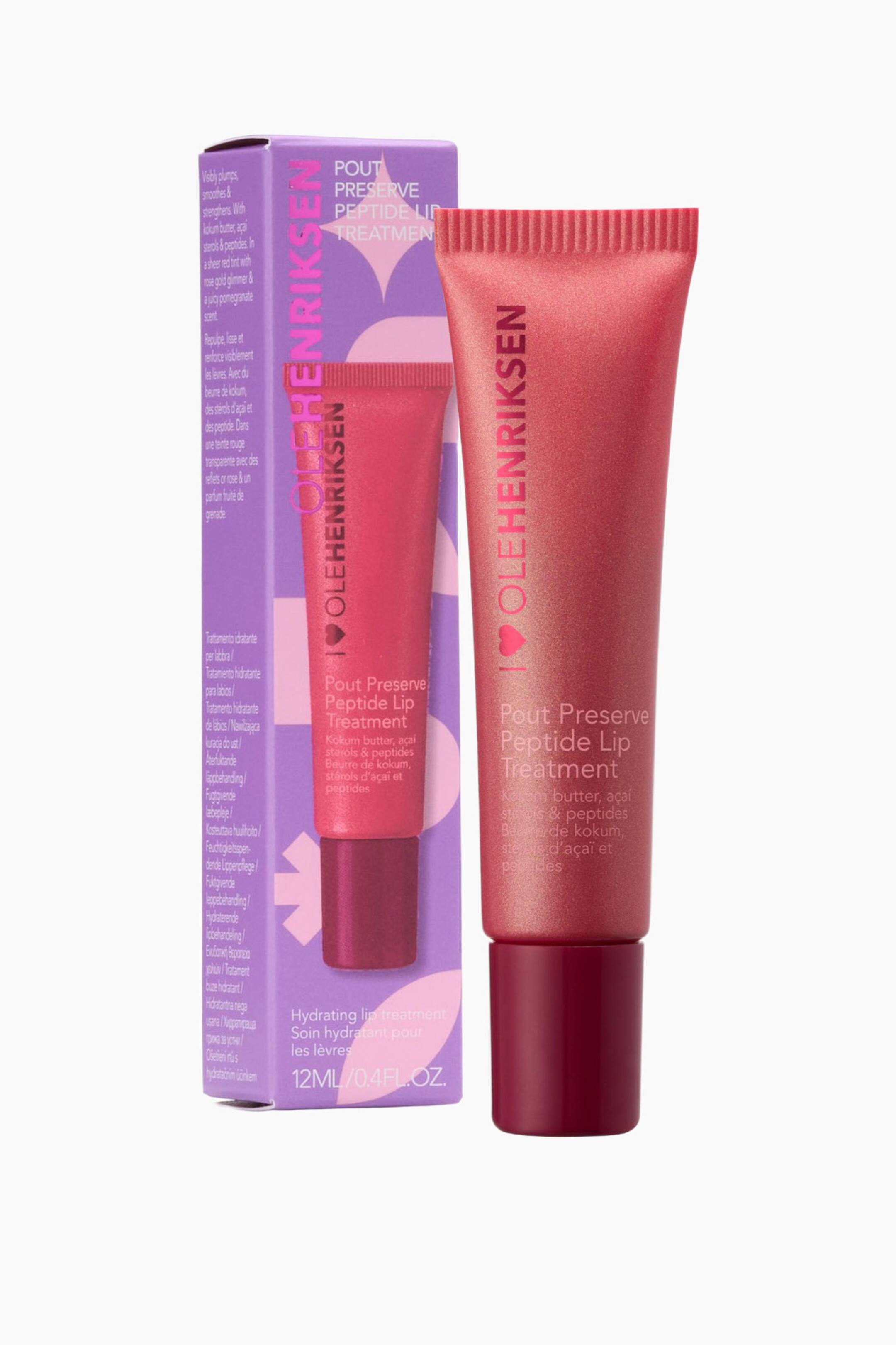 Vis større bilde: En Ole Henriksen Pout Preserve Peptide Lip Treatment-tube står oppreist, vinklet litt mot høyre, og viser sin skimrende rødrosa farge og mørk burgunderrød skrulokk. Den medfølgende lilla produktboksen, med samme merkevare og et mindre trykt bilde av tuben, er plassert rett bak den.