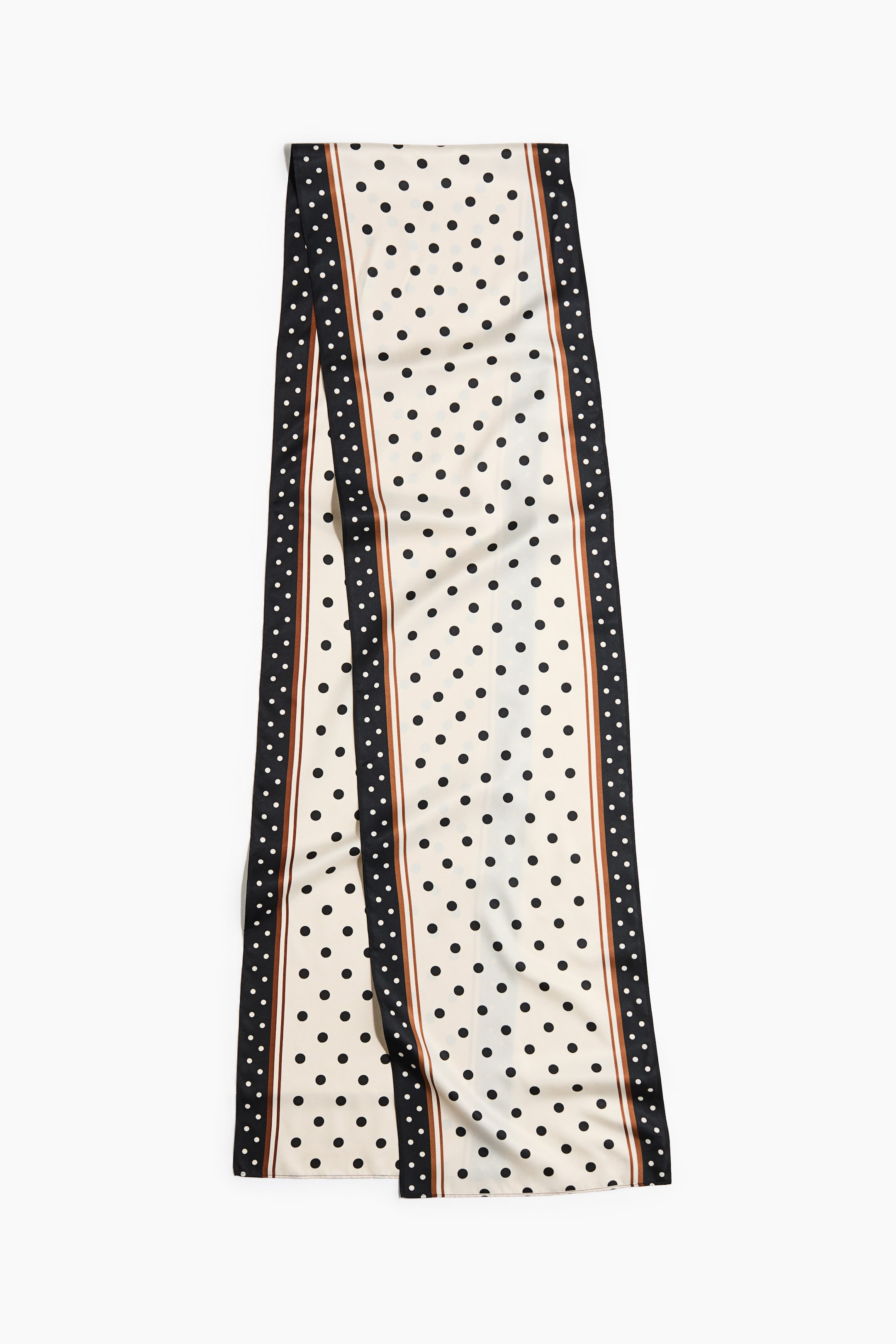 הצגת תמונה גדולה יותר: צעיף סאטן מודפס ארוך פרוש שטוח, עם רקע קרם המעוטר בנקודות פולקה שחורות. החלק המרכזי מוקף משני צידיו הארוכים בפס דק חום, ולאחריו מסגרת שחורה רחבה יותר עם נקודות לבנות קטנטנות.