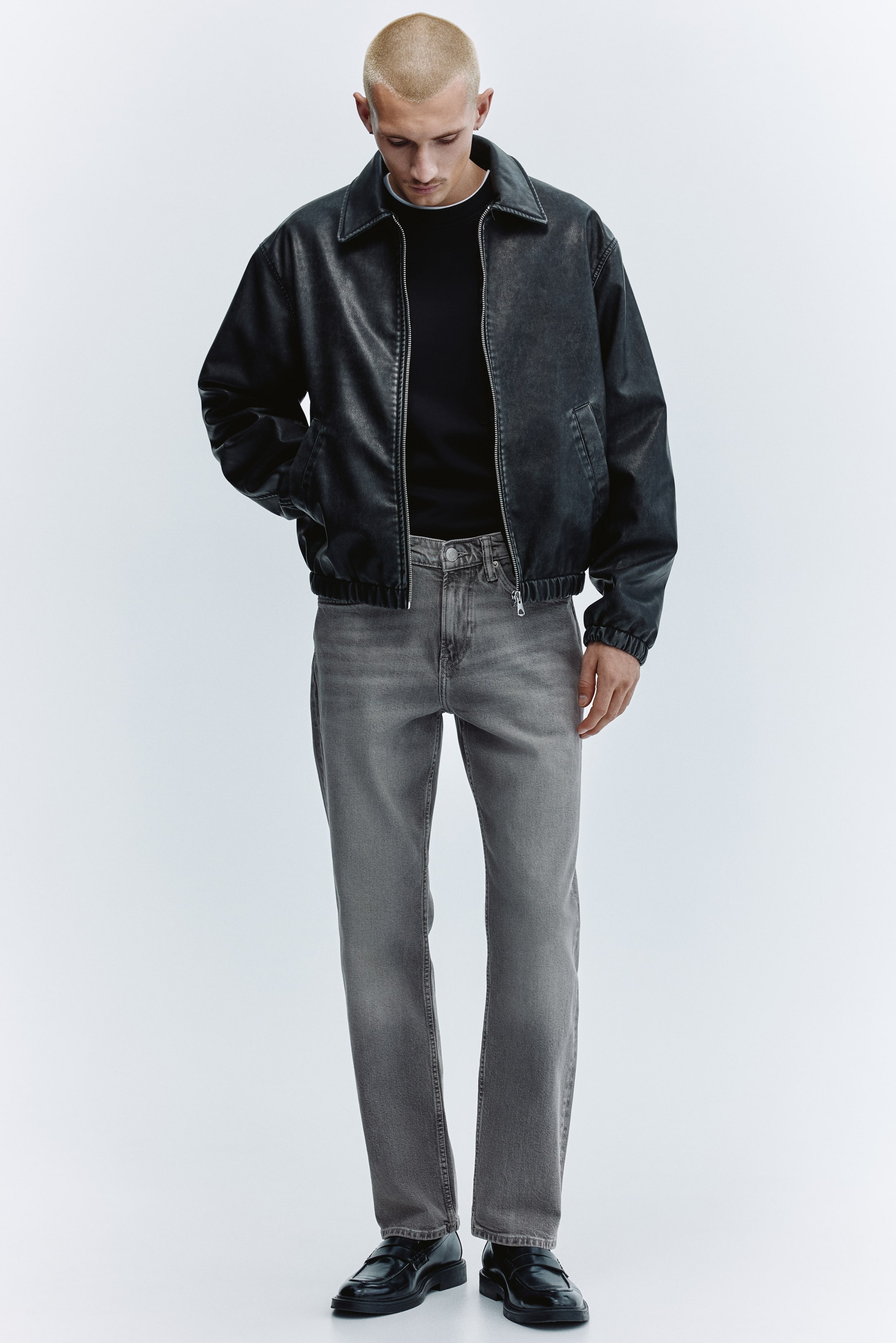 View larger image: The dark grey distressed-look bomber jacket is presented front-on, featuring a spread collar, a full-zip closure and ribbed cuffs and hem. A black t-shirt is worn underneath, with its crew-neck collar visible.