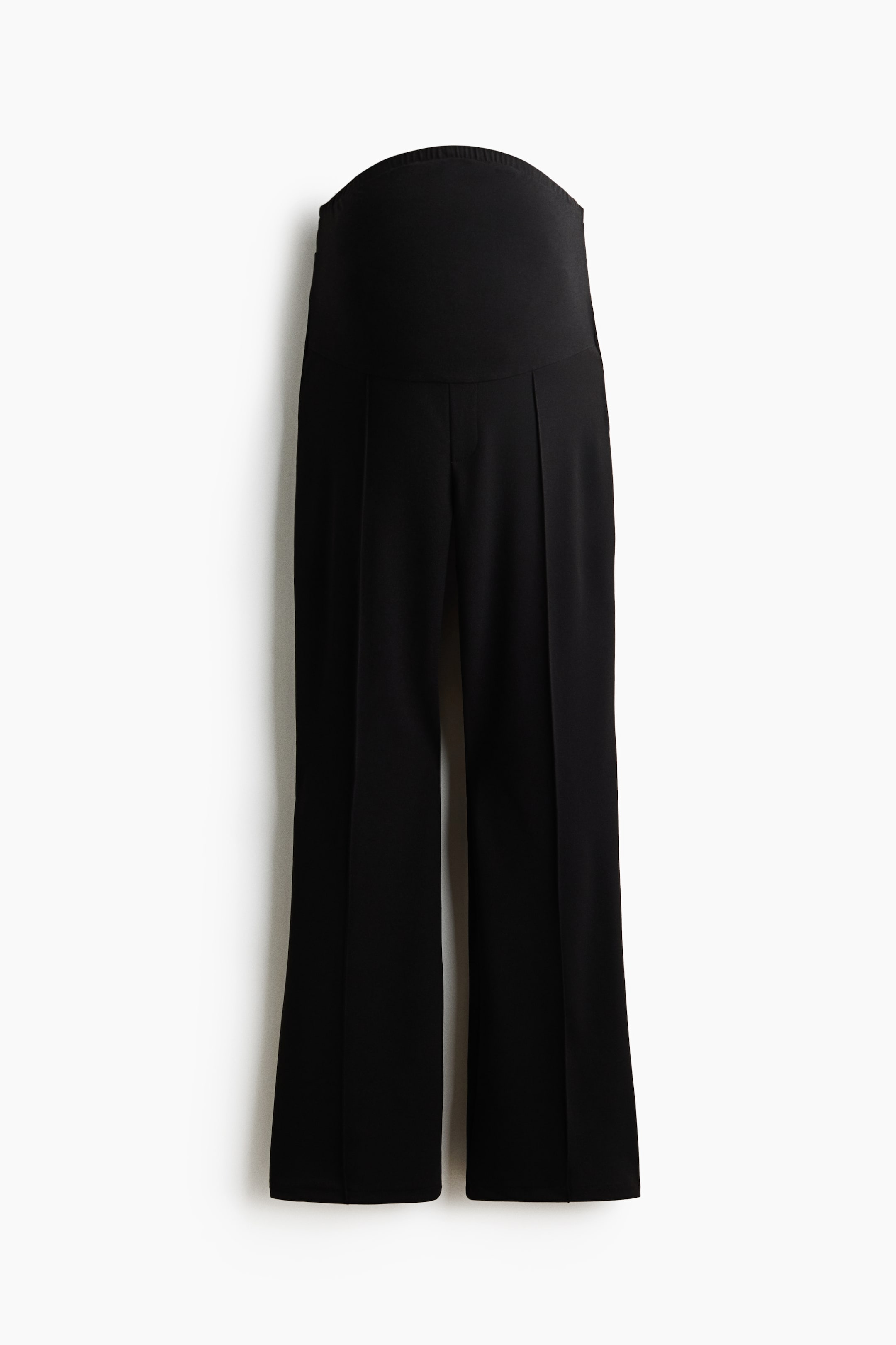 View larger image: A pair of black wide-leg maternity trousers is shown from the front, featuring a high, elasticated over-the-bump waistband. The trousers display sharp pressed creases running down the centre of each leg.